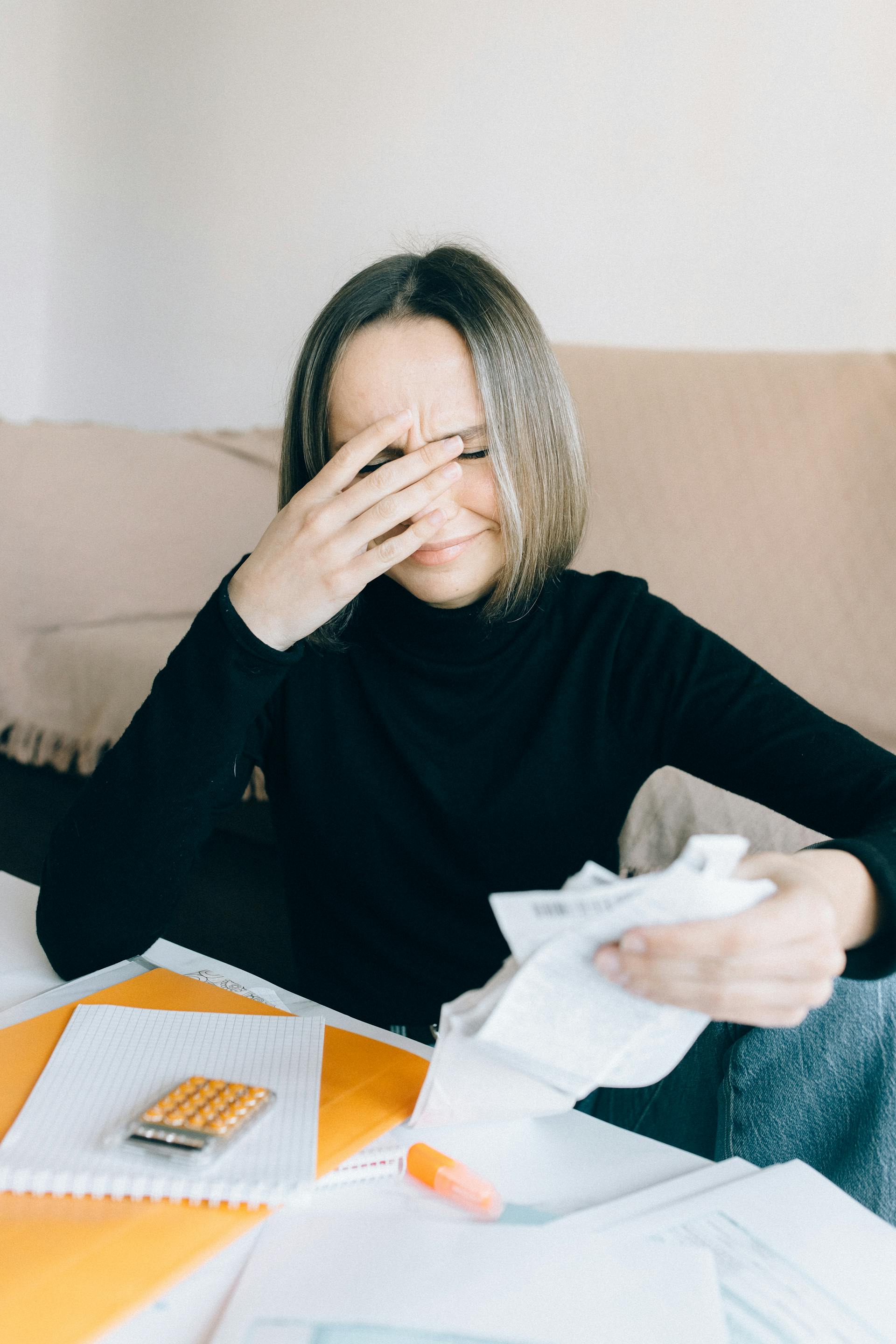 An emotional woman holding receipts | Source: Pexels