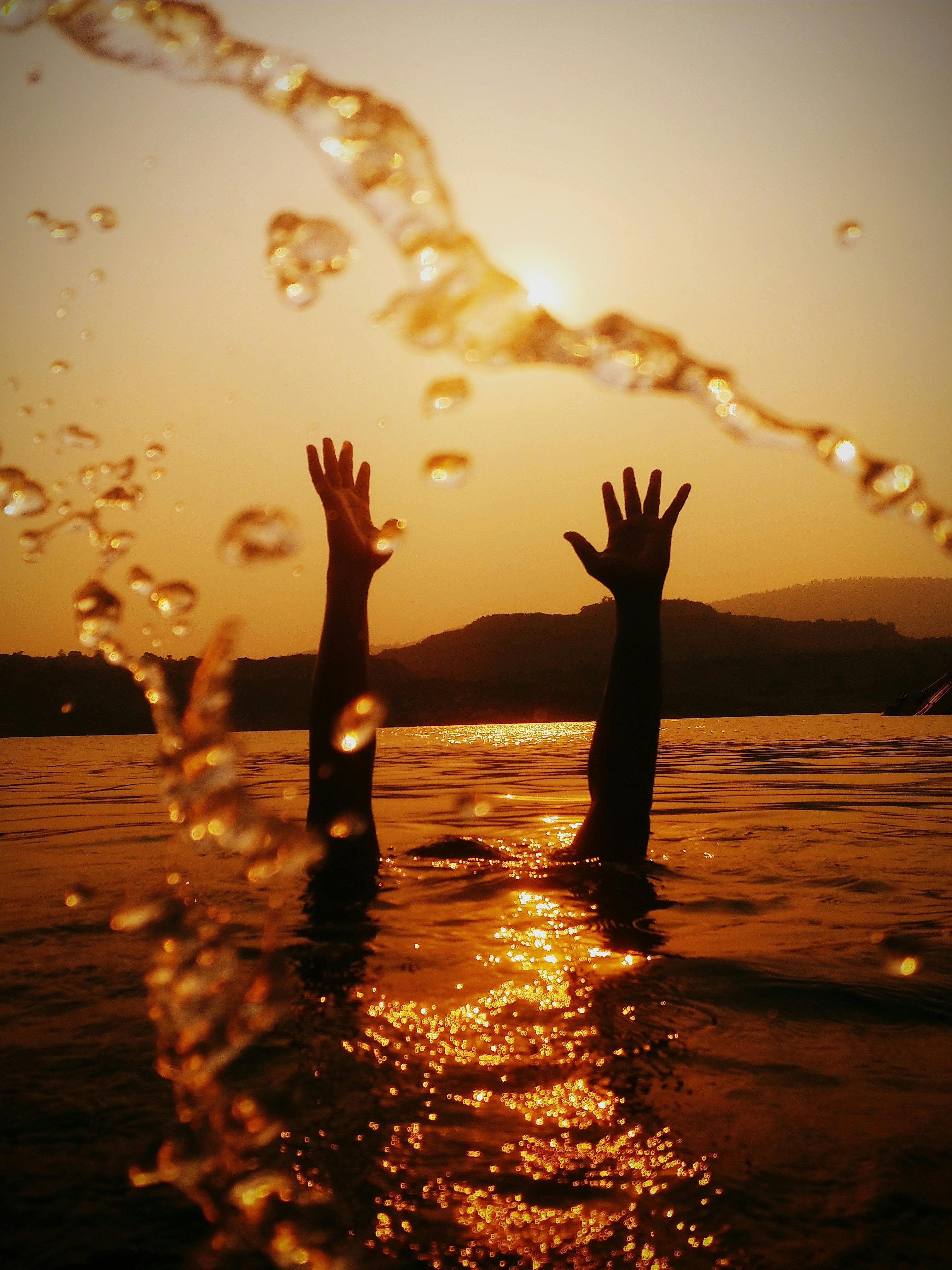 Hands above water surface | Source: Pexels