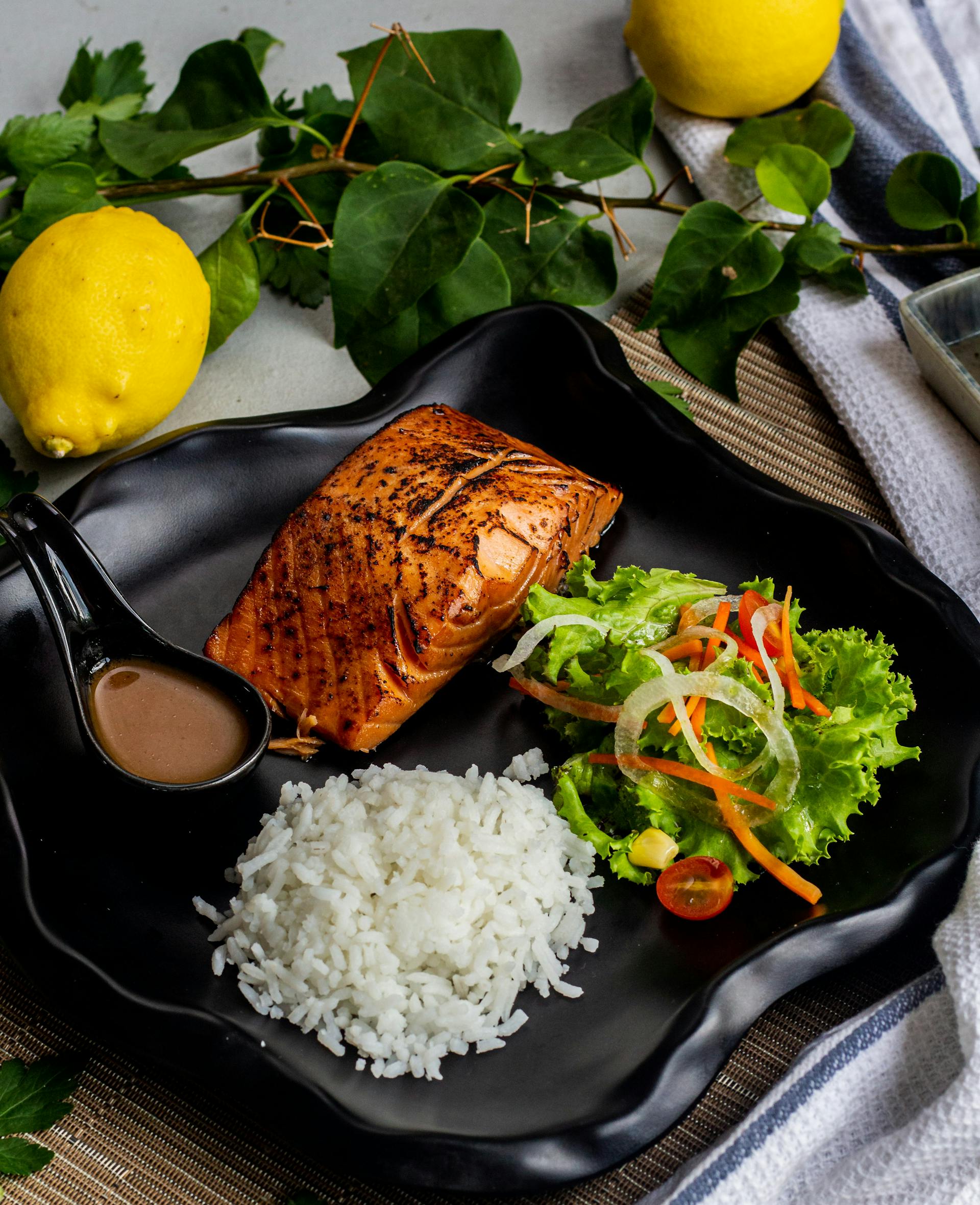Grilled fish and rice served with vegetables on a plate | Source: Pexels
