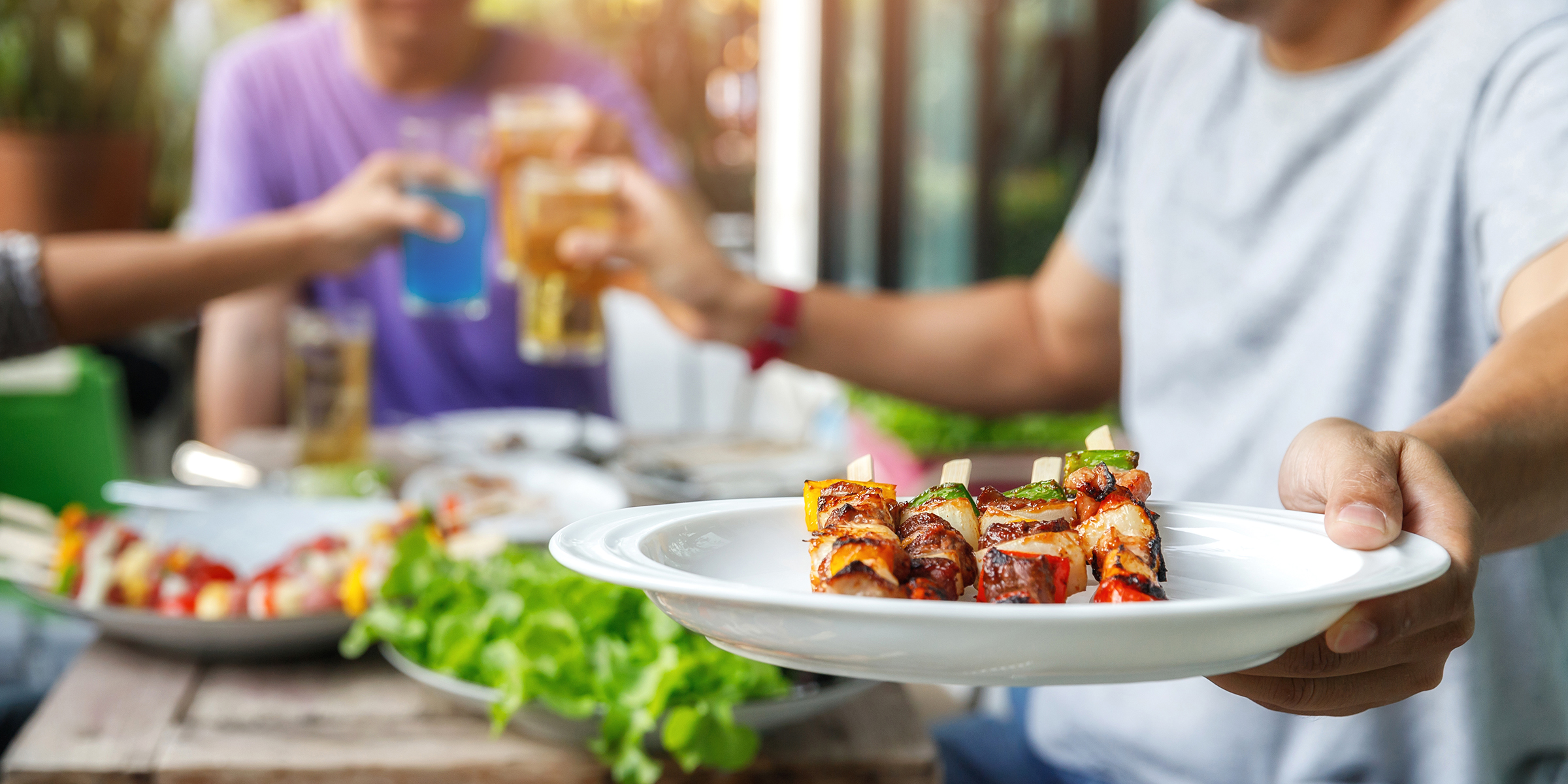 A man holding a barbecue plate at a party | Source: Shutterstock