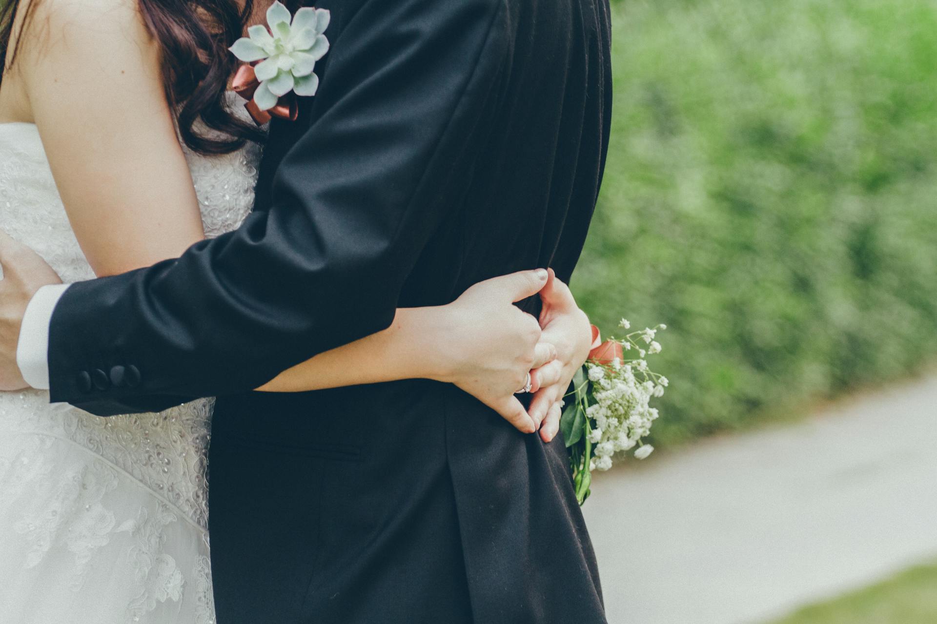 Un couple de jeunes mariés se faisant un câlin | Source : Pexels