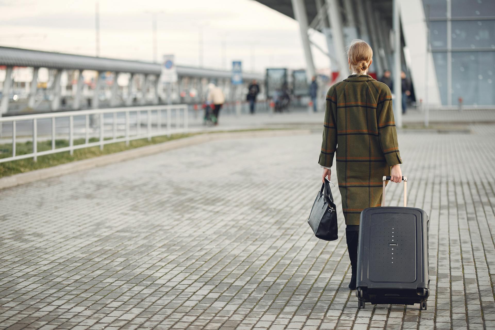 Una mujer caminando con sus bolsos | Fuente: Pexels