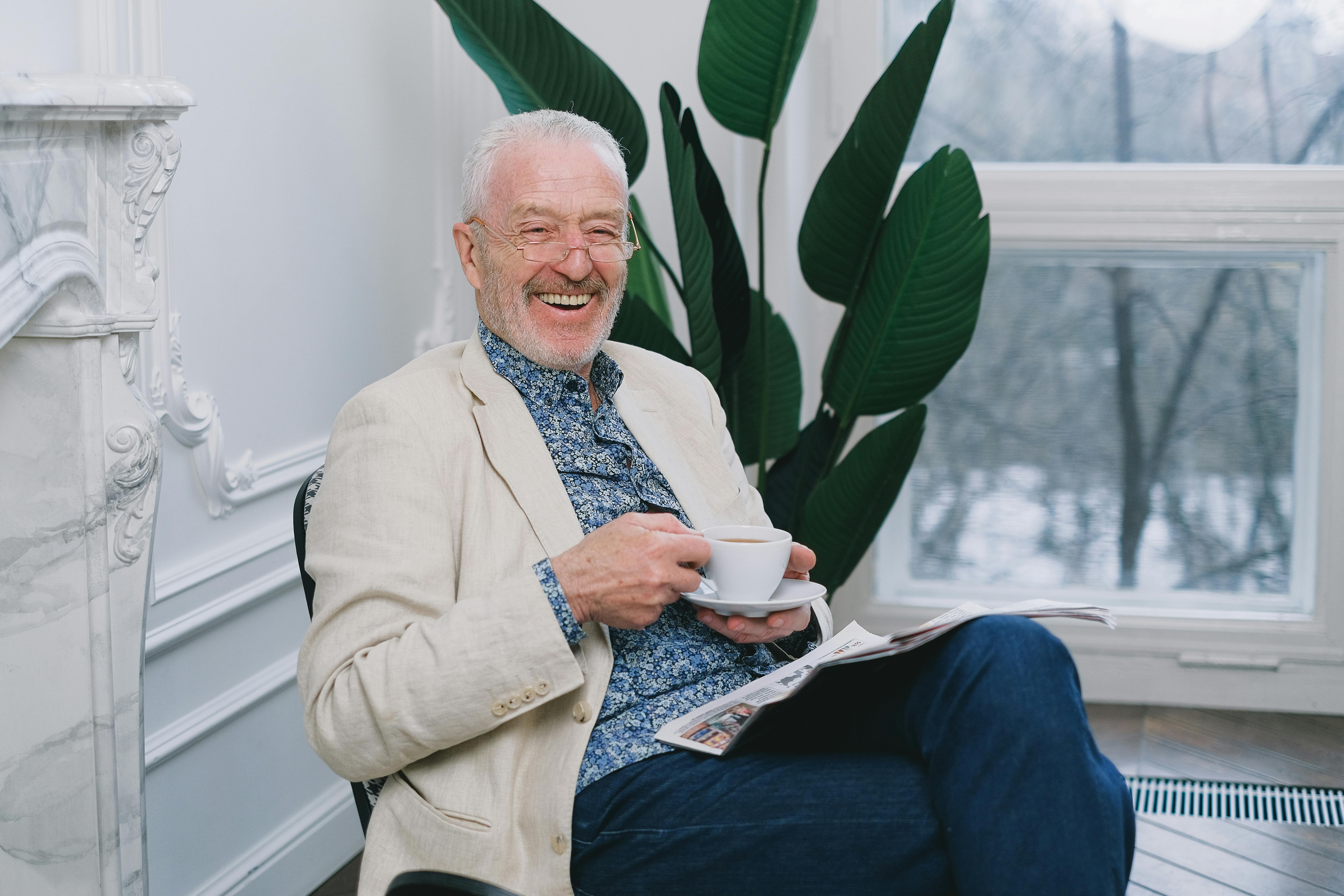 A man laughing while having tea | Source: Pexels