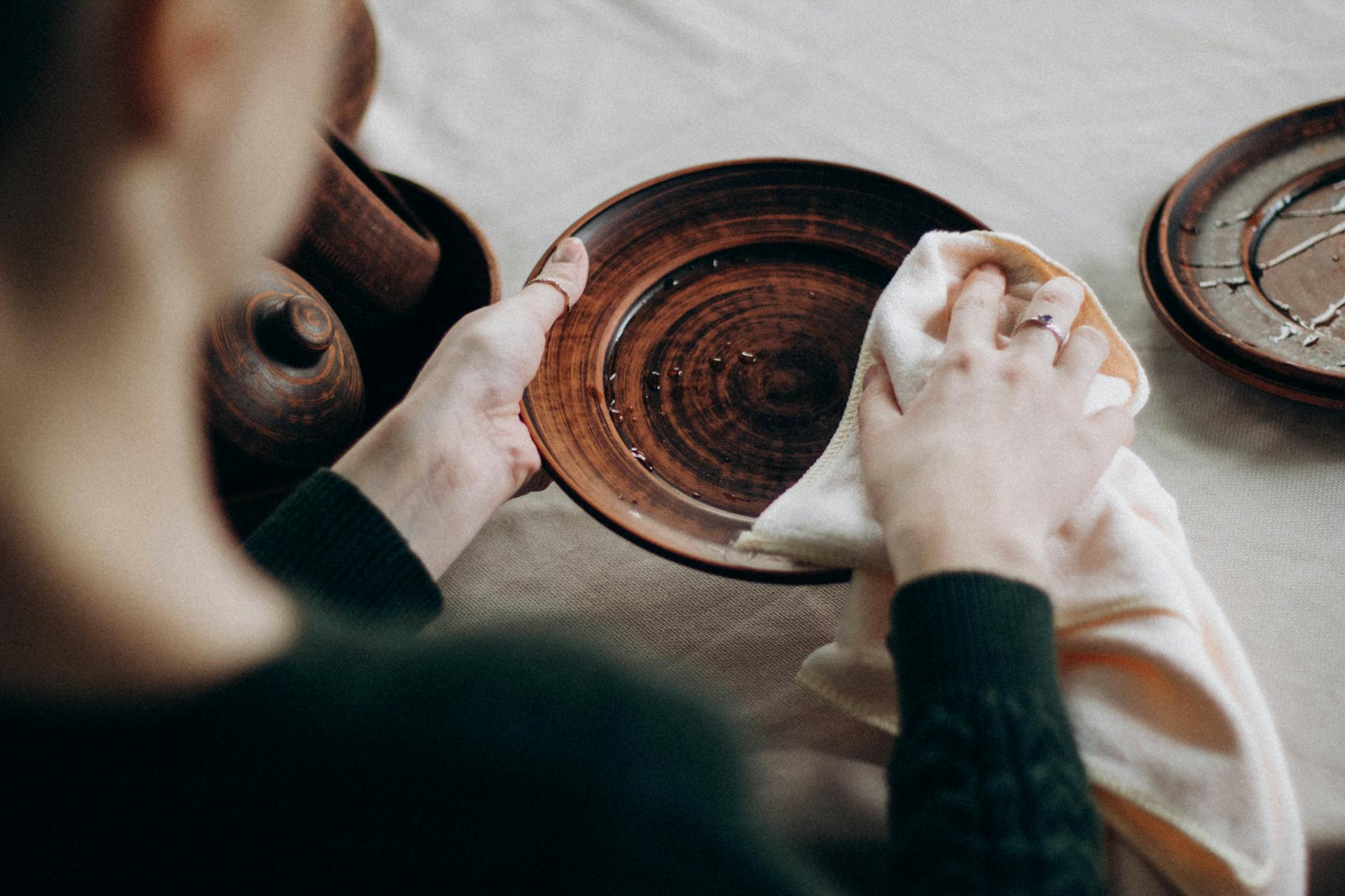 A woman wiping dishes | Source: Pexels