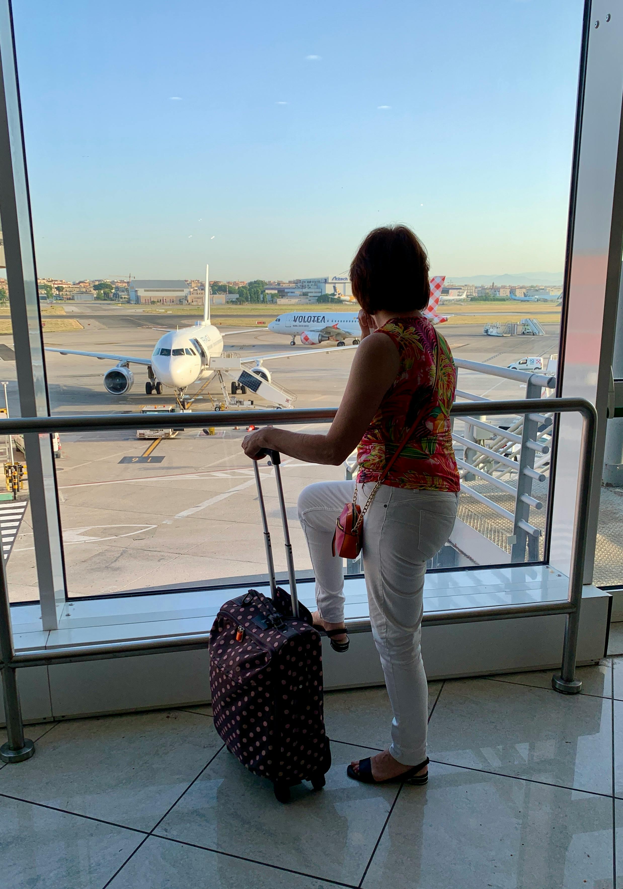 Woman with luggage waiting inside an airport | Source: Pexels
