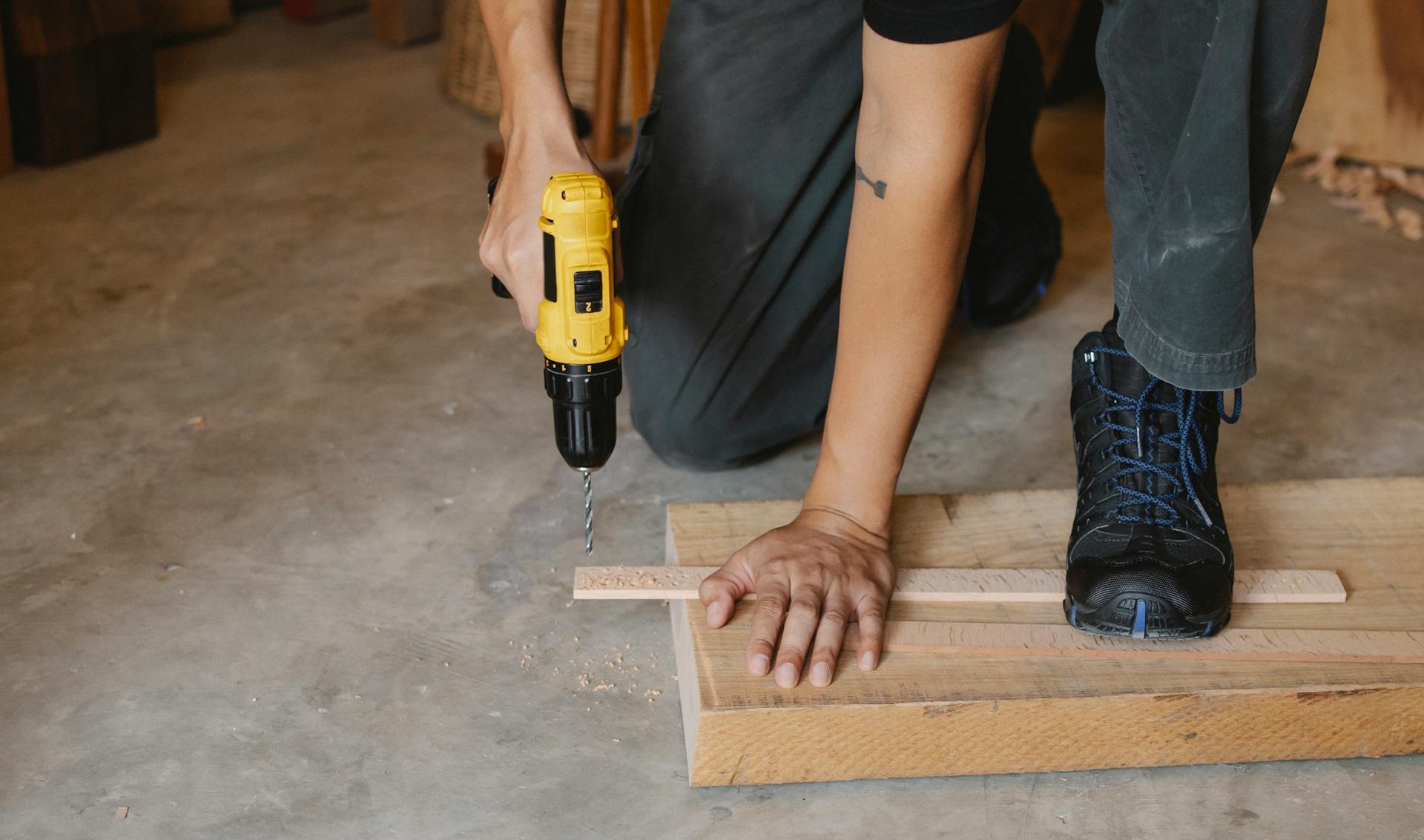 A man drills into wood | Source: Pexels