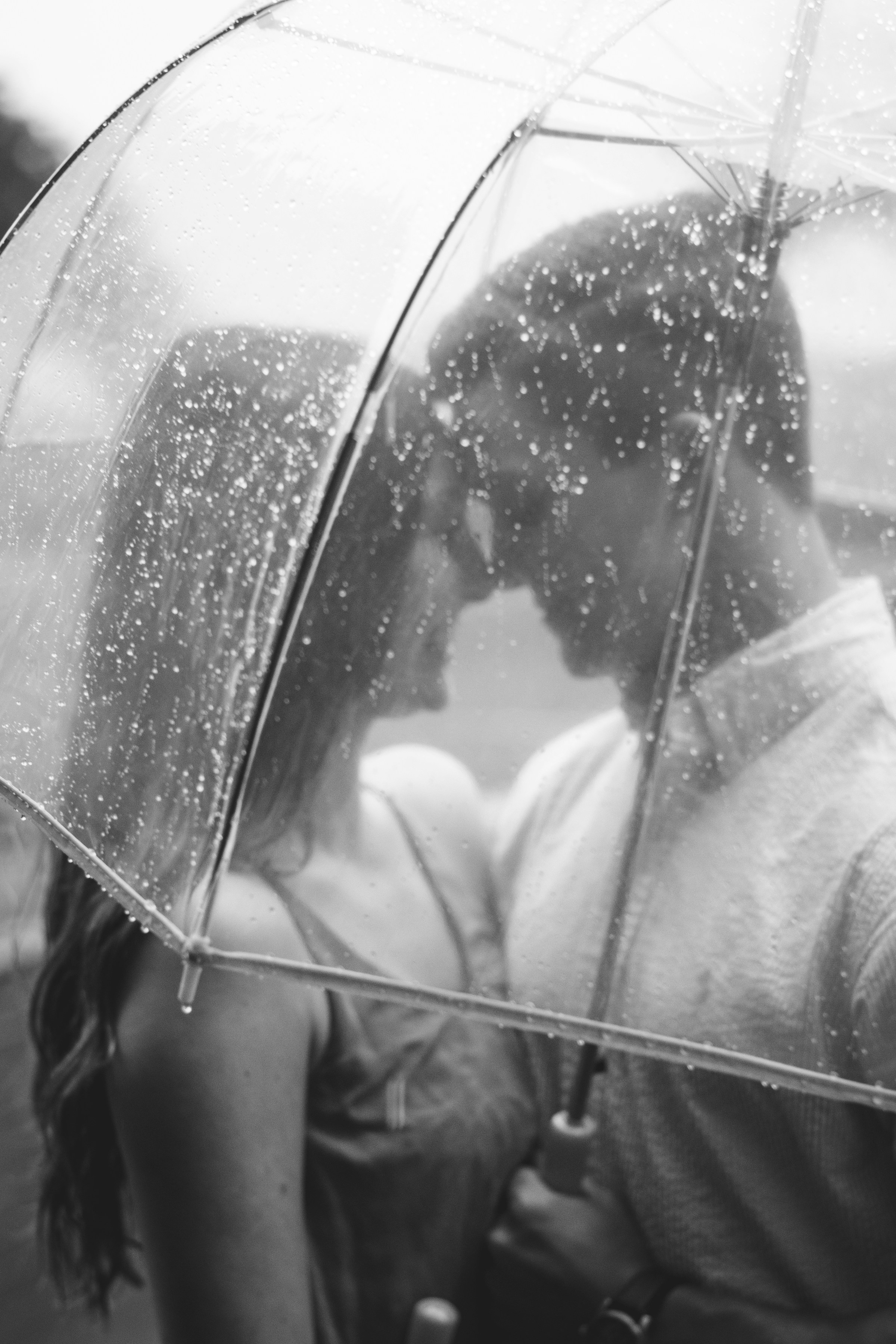 Grayscale shot of a couple holding an umbrella | Source: Unsplash