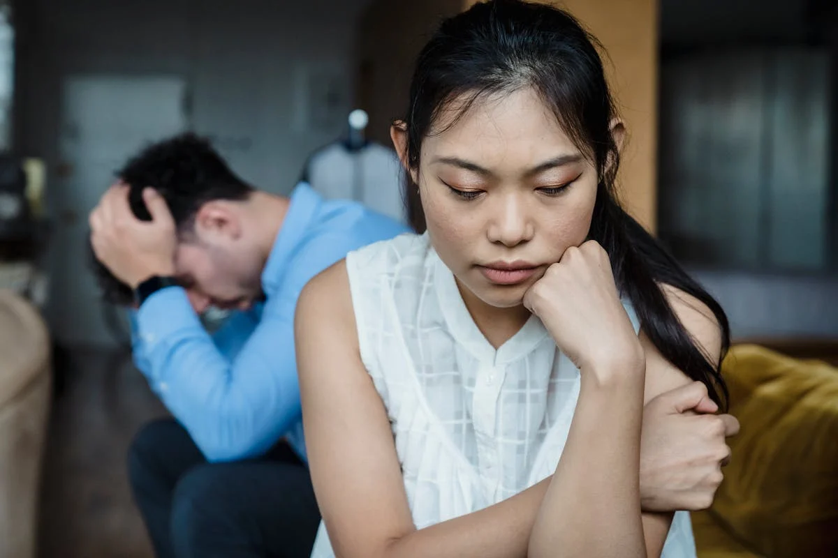 A sad woman with her back turned to a distraught man | Source: Pexels