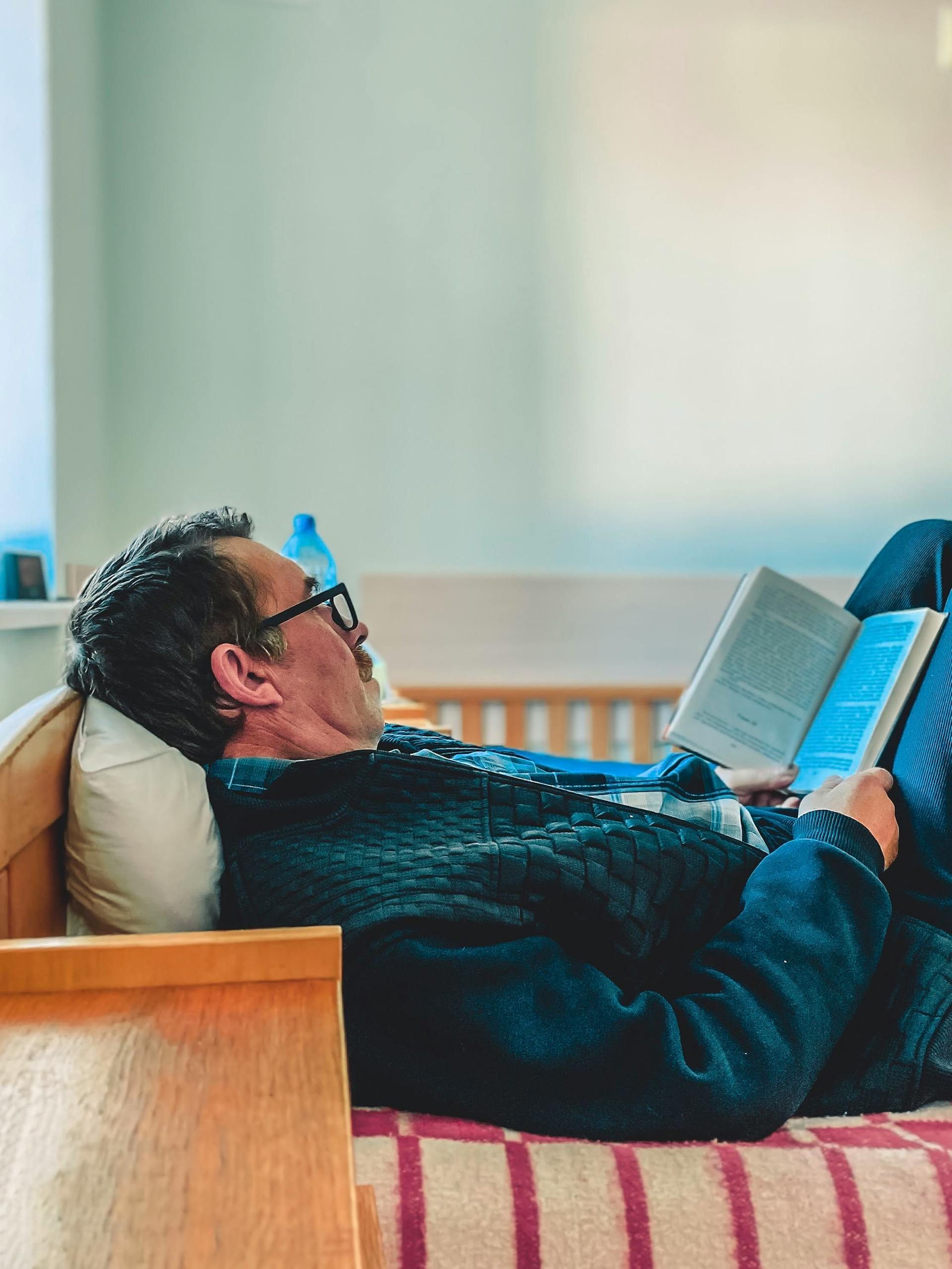 A man lying in bed reading | Source: Pexels