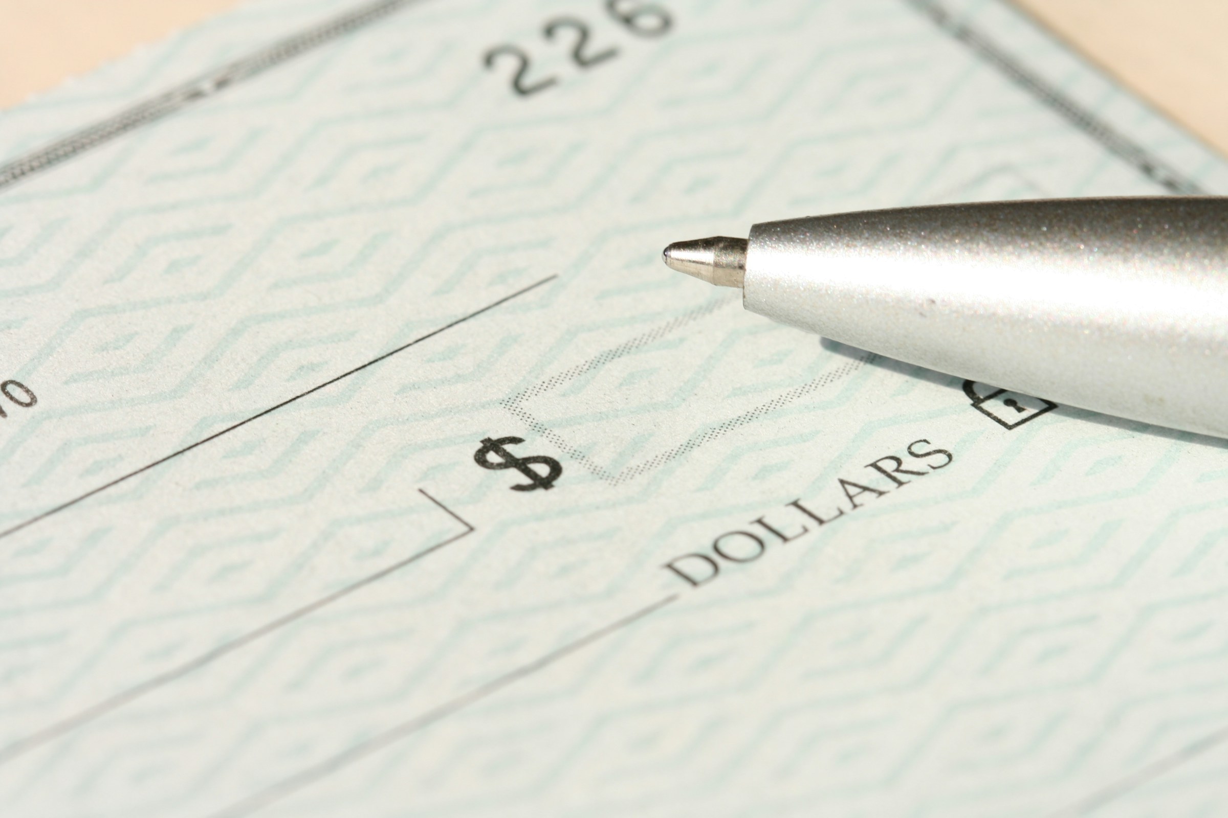 Pen lying on top of a bank check | Source: Unsplash