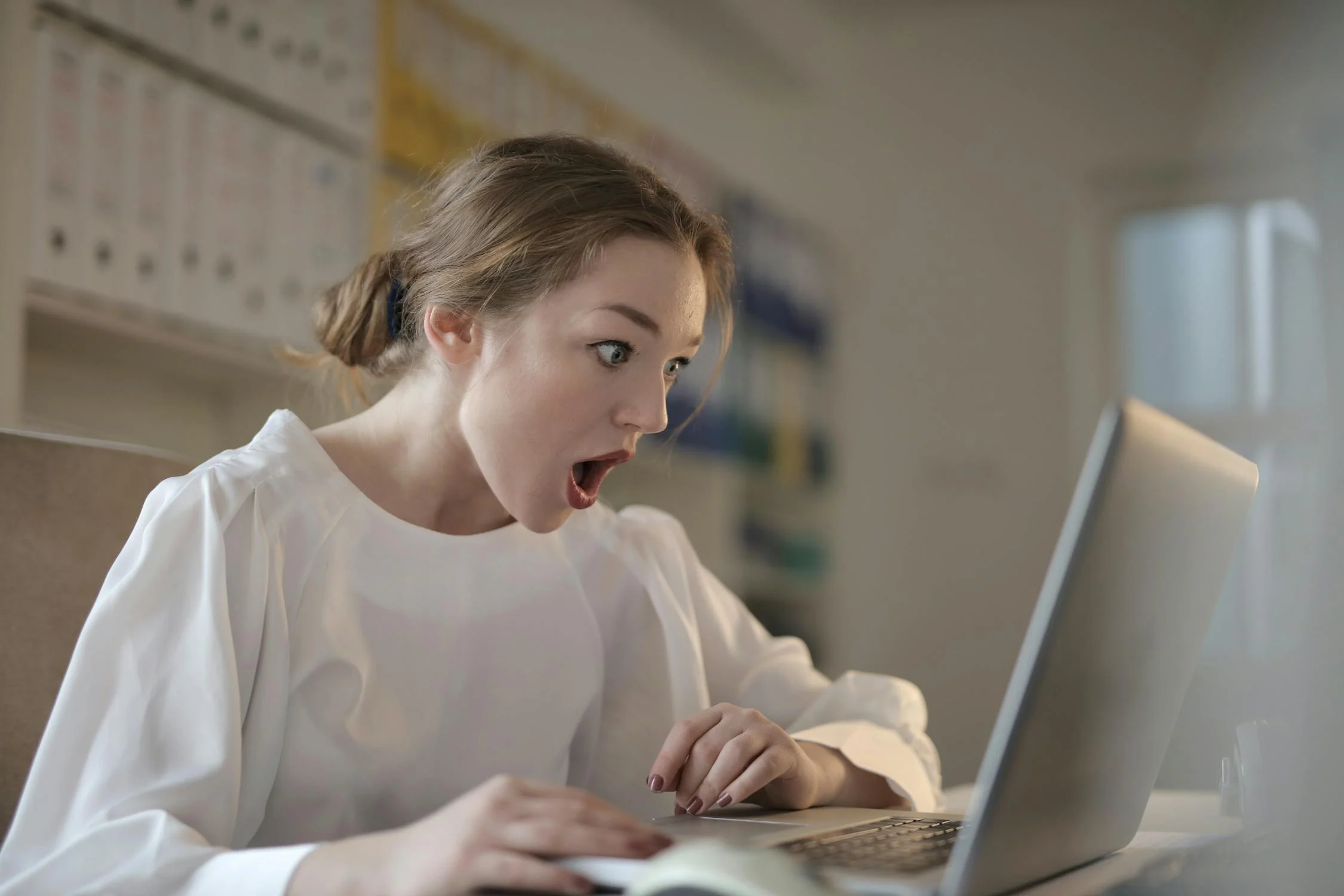 Uma mulher chocada olhando para seu laptop | Fonte: Pexels