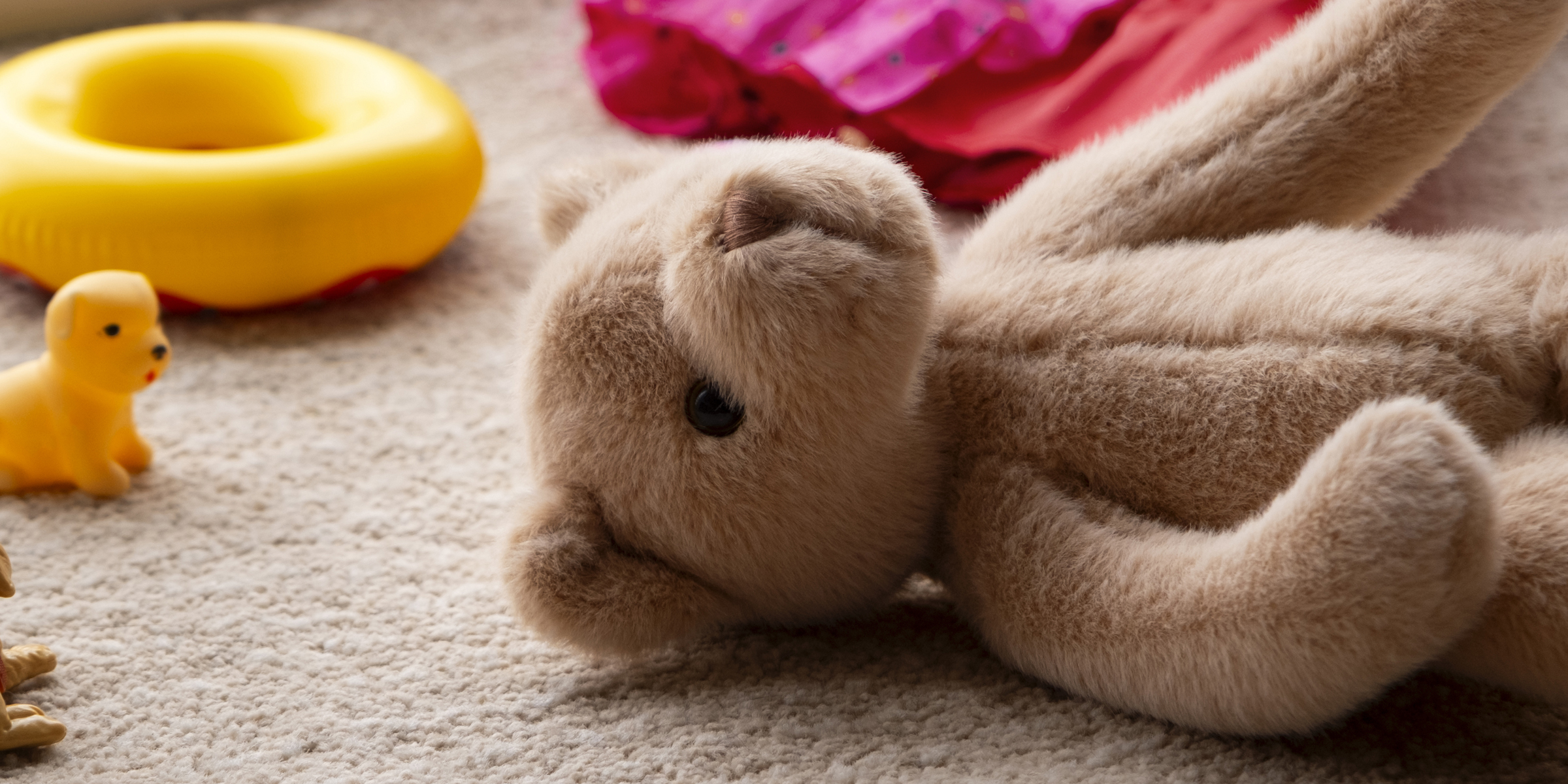 A teddy bear lying on a carpeted floor | Source: Freepik