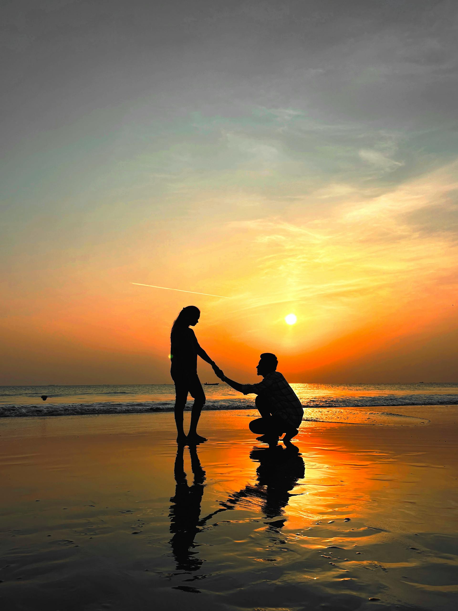 A distant shot of a romantic proposal on the beach | Source: Pexels