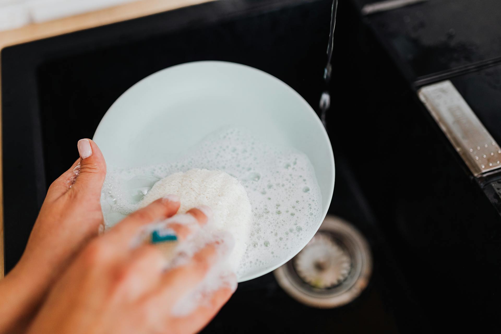 A woman washing a plate | Source: Pexels