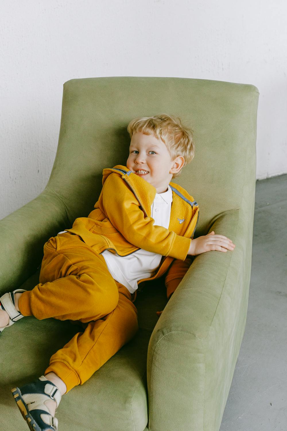 A beaming boy in a chair | Source: Pexels