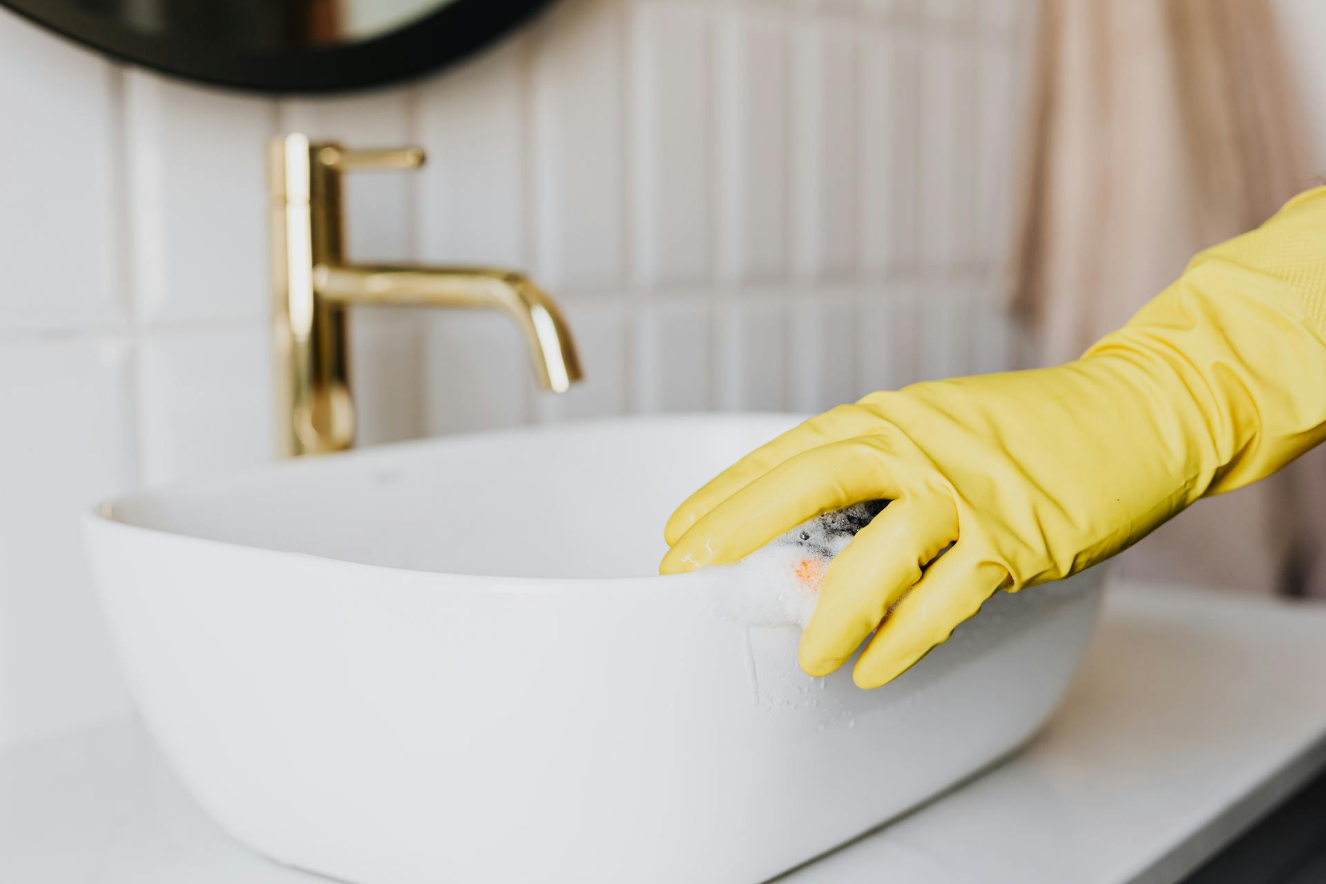 A person cleaning a bathroom sink | Source: Pexels