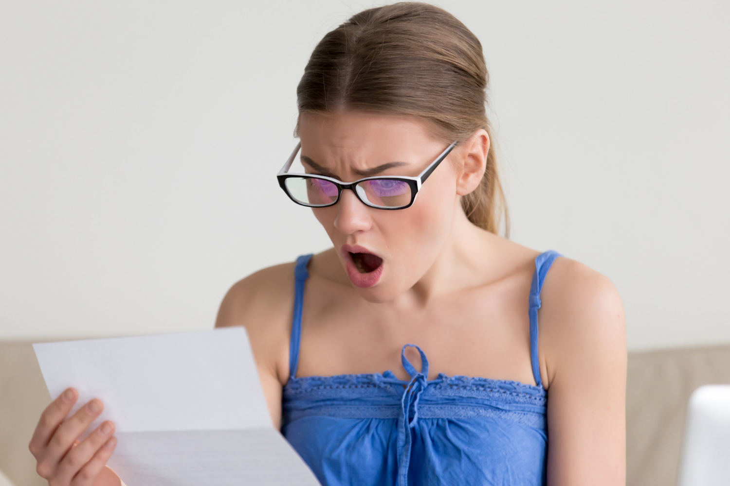 A shocked woman reading a letter | Source: Freepik