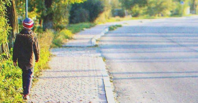 A kid walking down a street | Source: Shutterstock