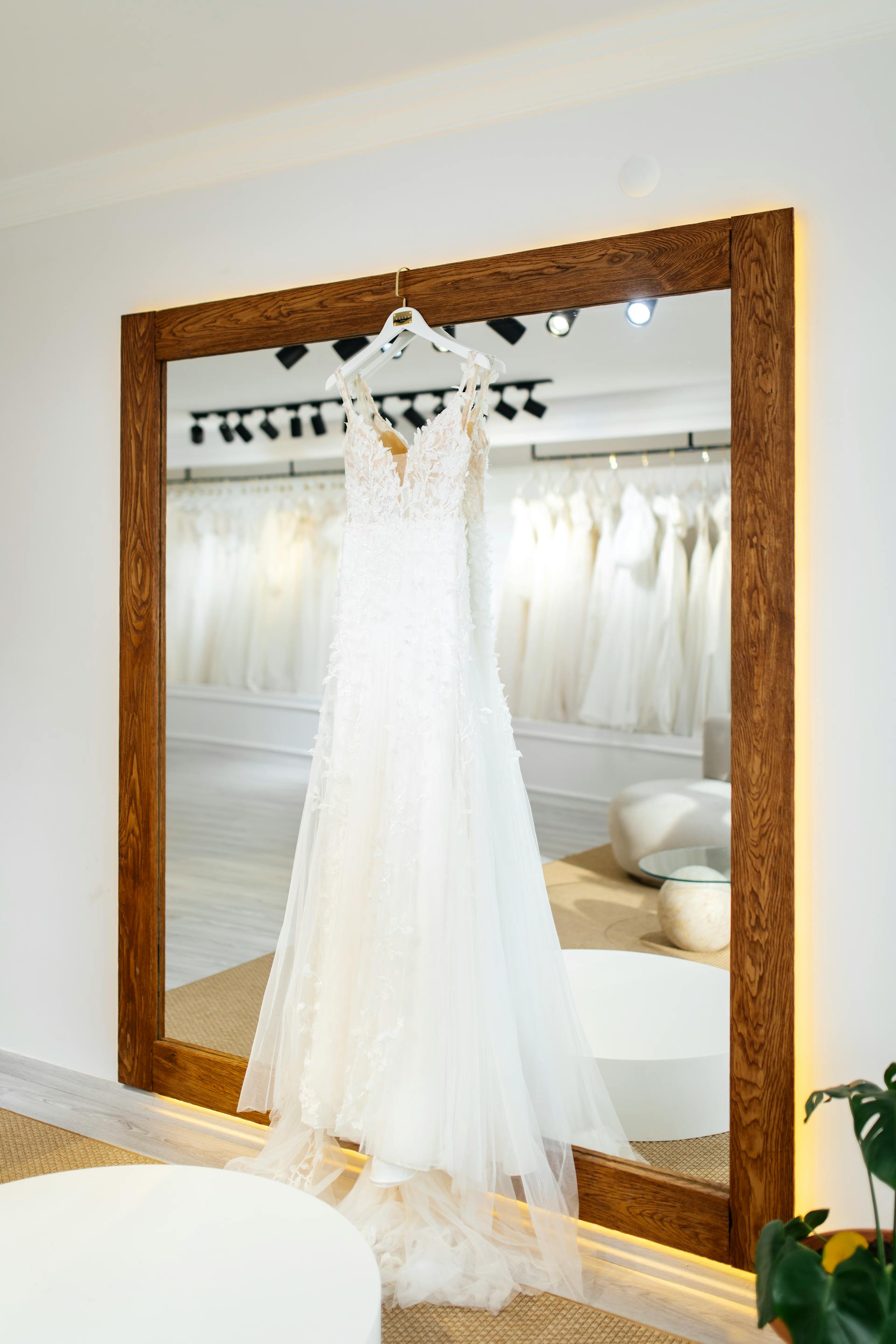 A white wedding dress hanging on a mirror frame | Source: Pexels