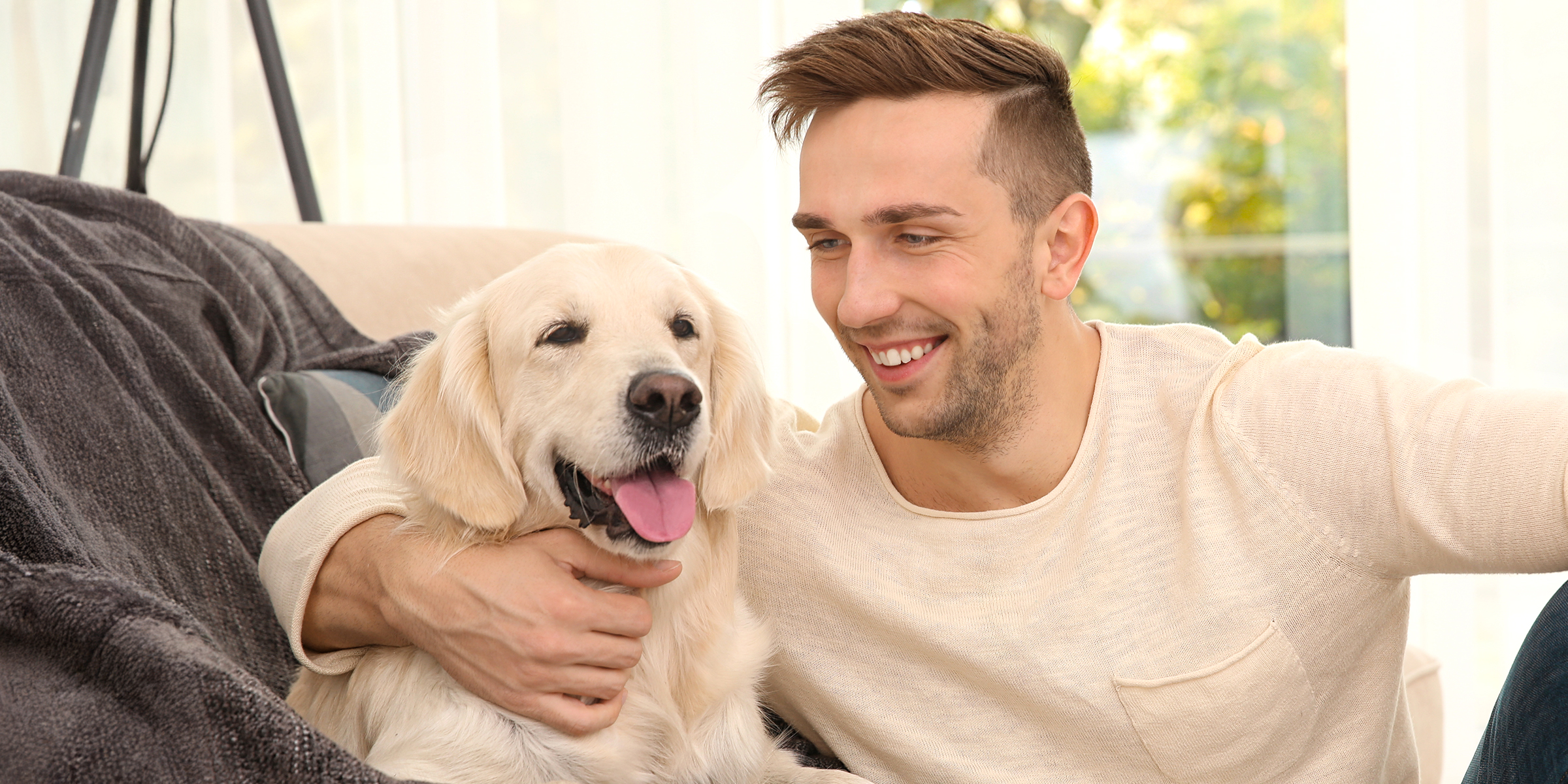 A man cuddling a dog | Source: Shutterstock