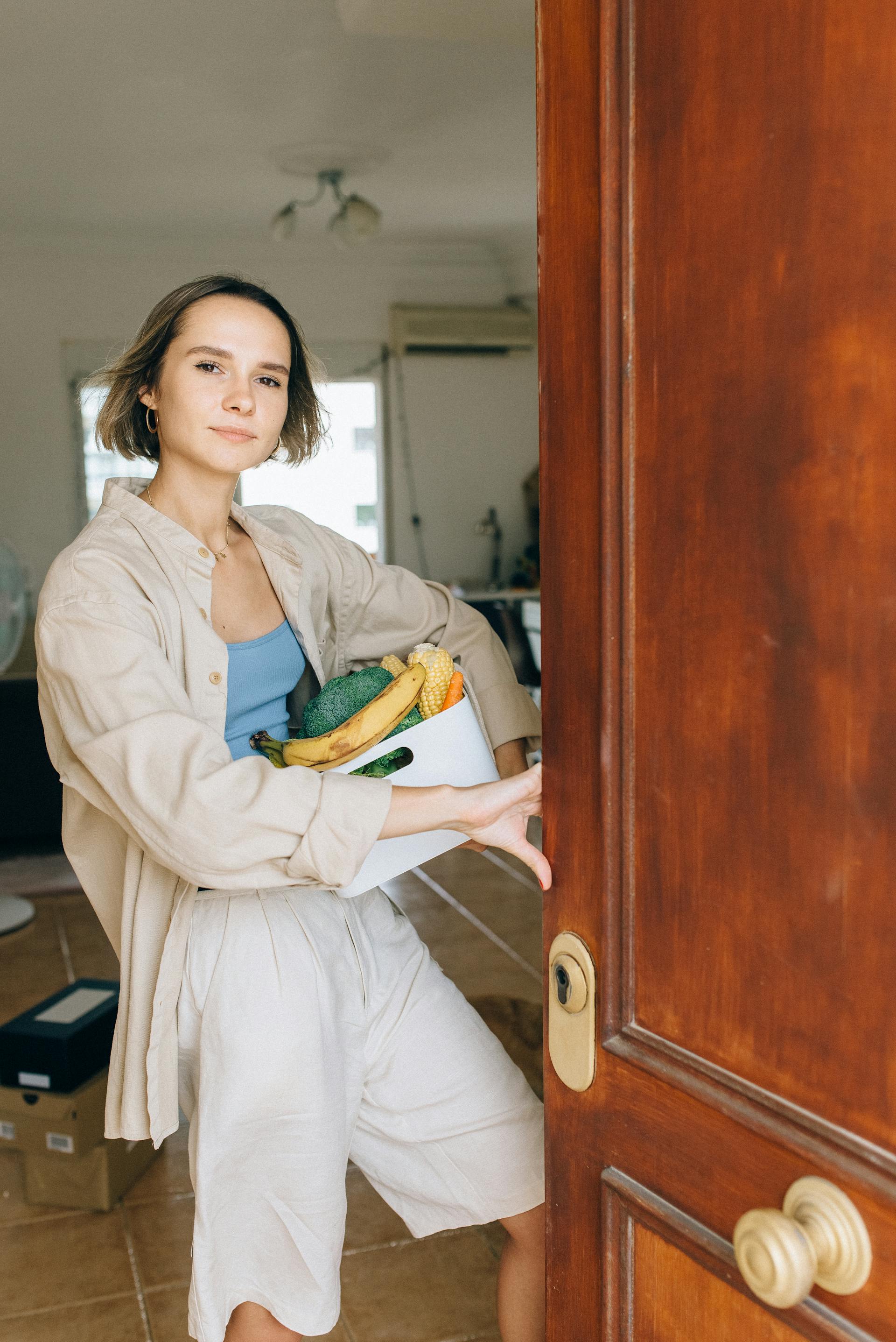 A woman standing in the open doorway of her apartment | Source: Pexels