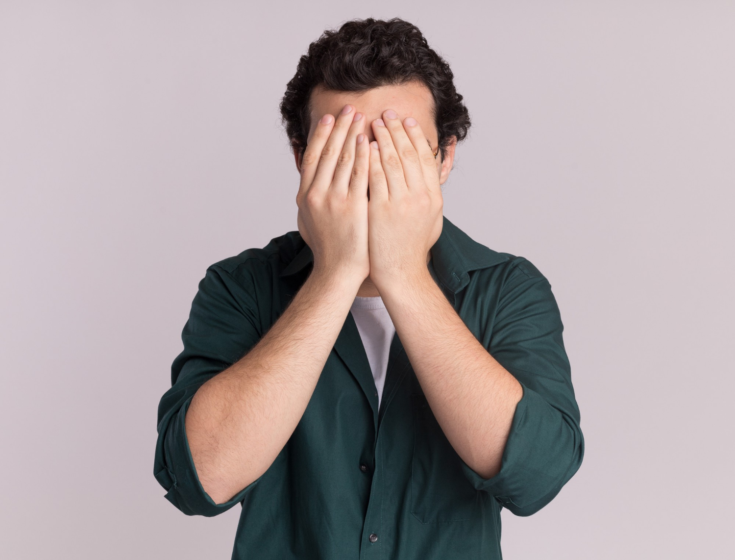 An upset man covering his face | Source: Freepik