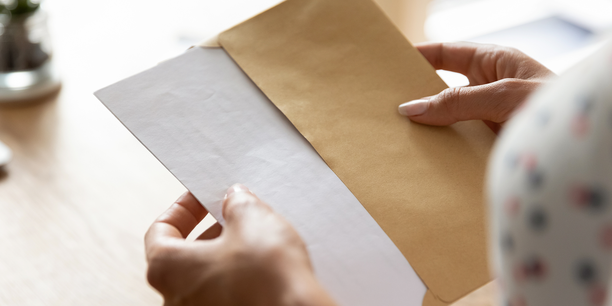 A woman holding an envelope | Source: Shutterstock