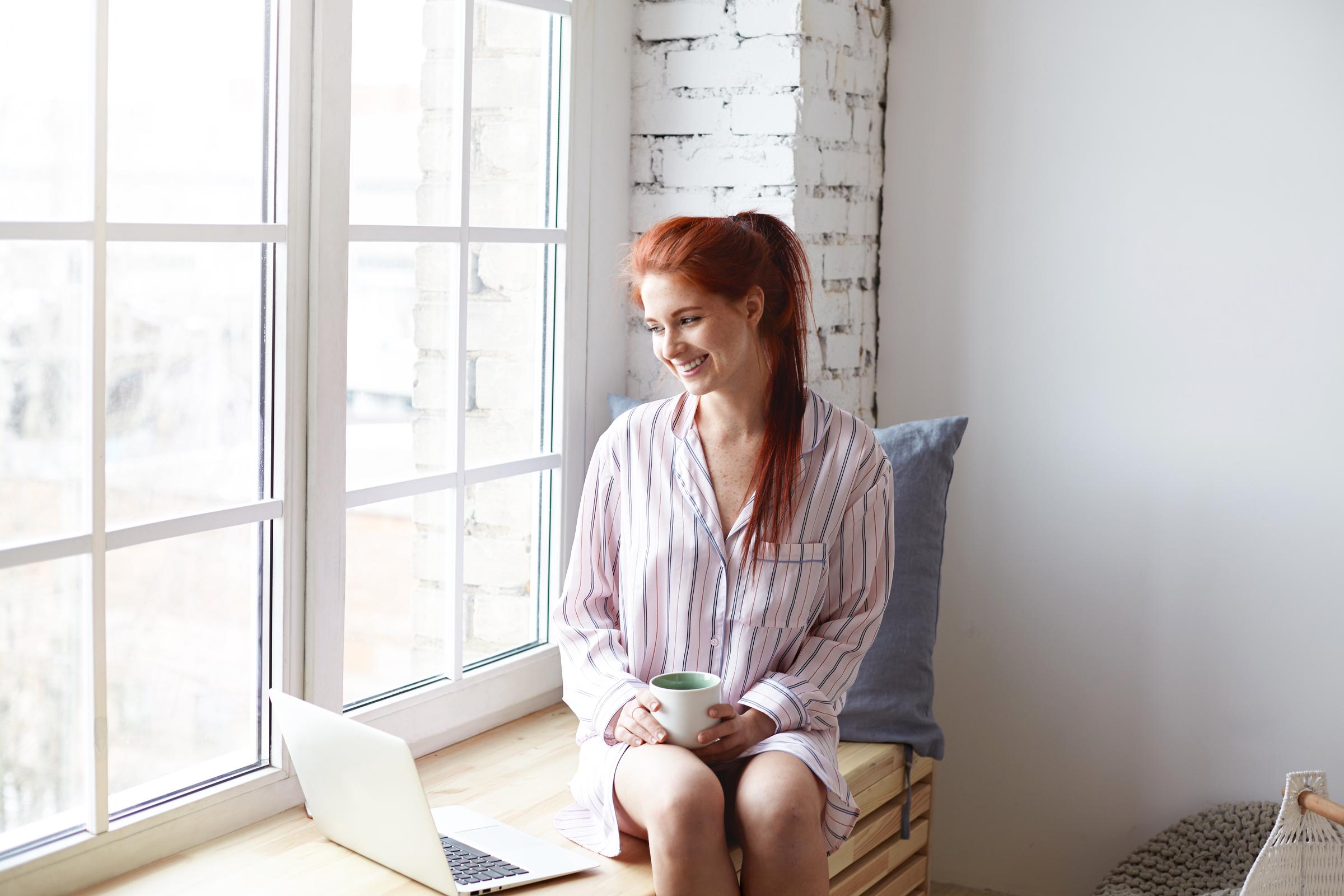 A happy woman using her laptop | Source: Freepik
