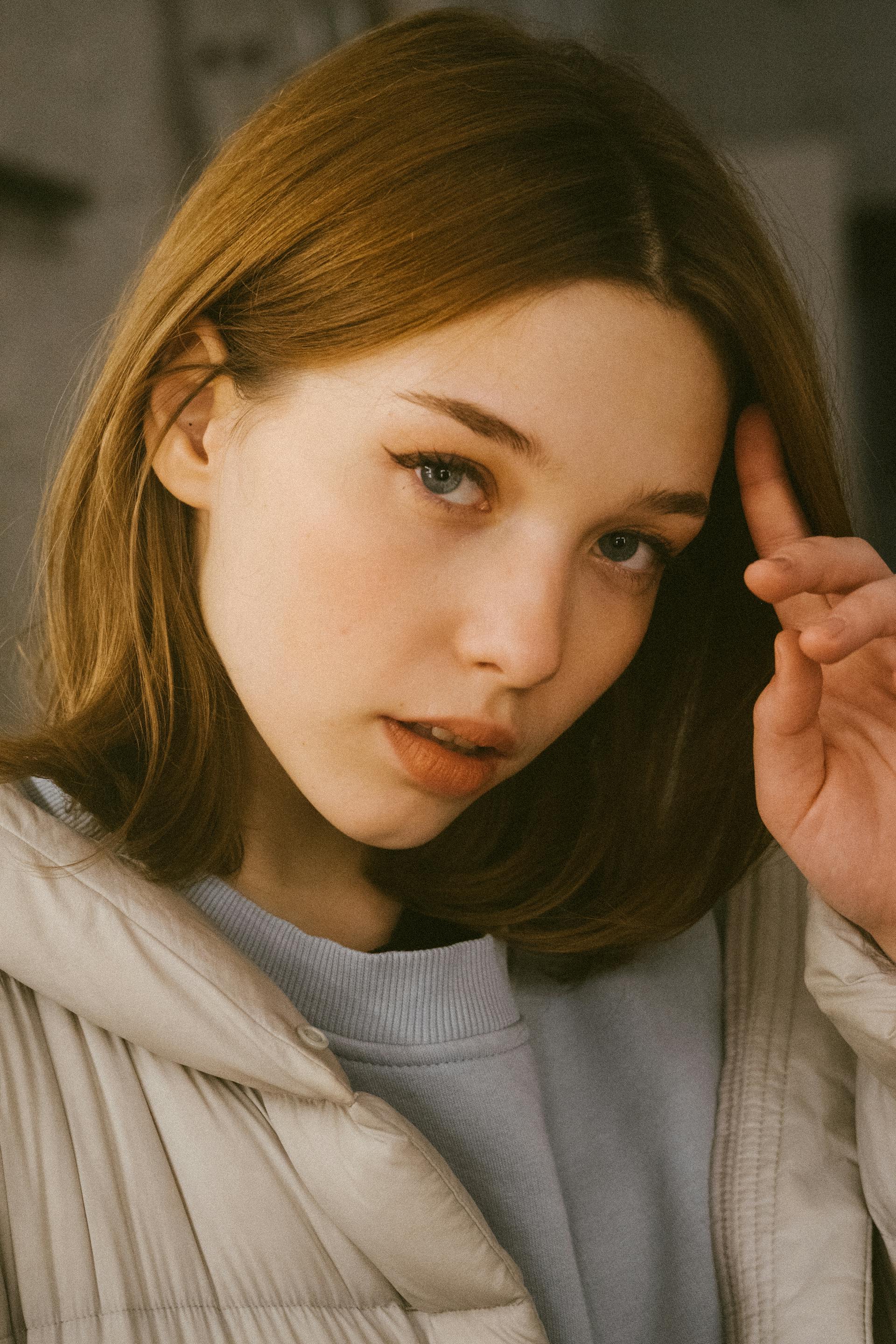 Close-up of a young woman running her finger through her hair | Source: Pexels