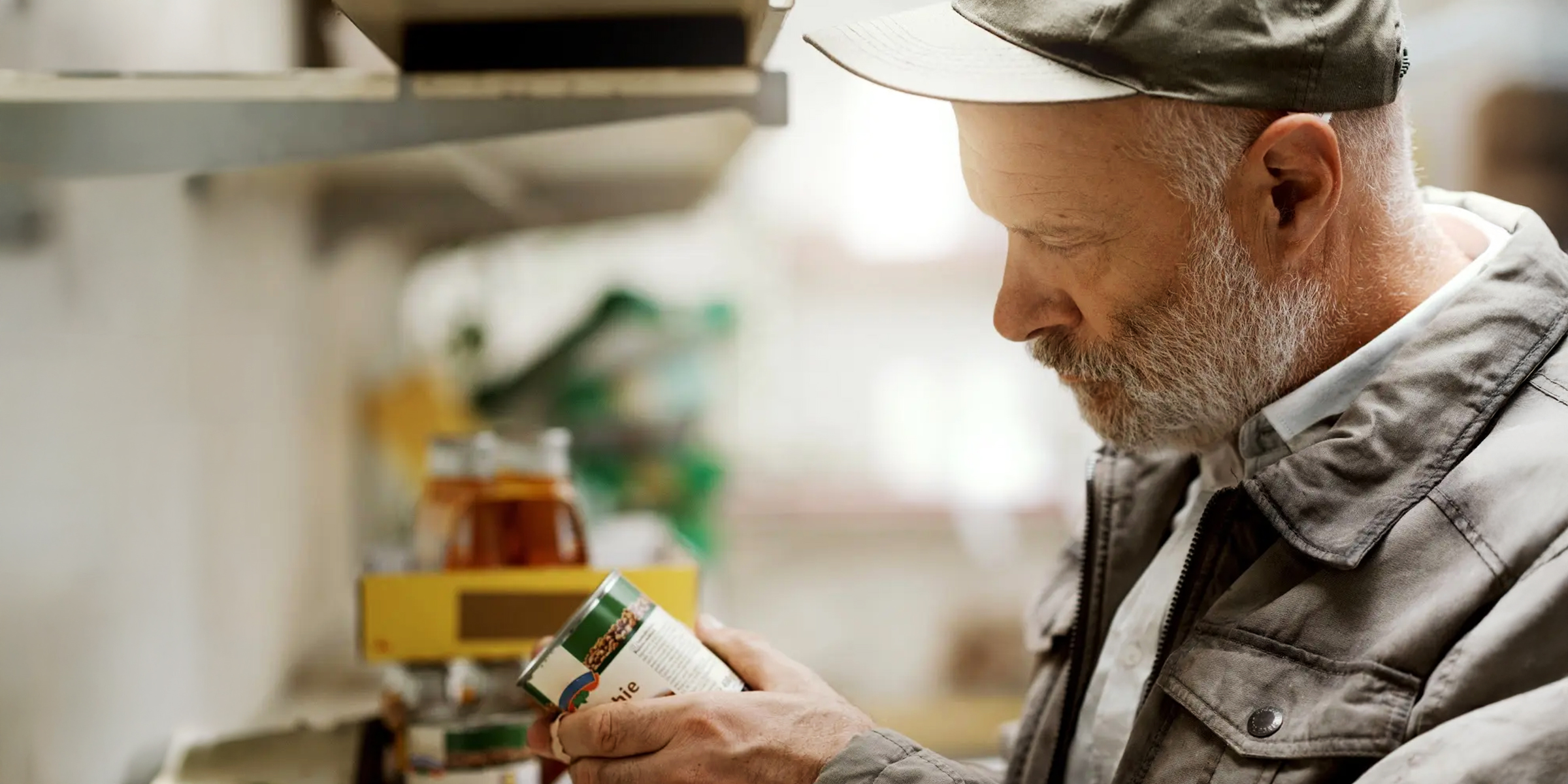 Homeless man looking intently at a can | Source: Shutterstock