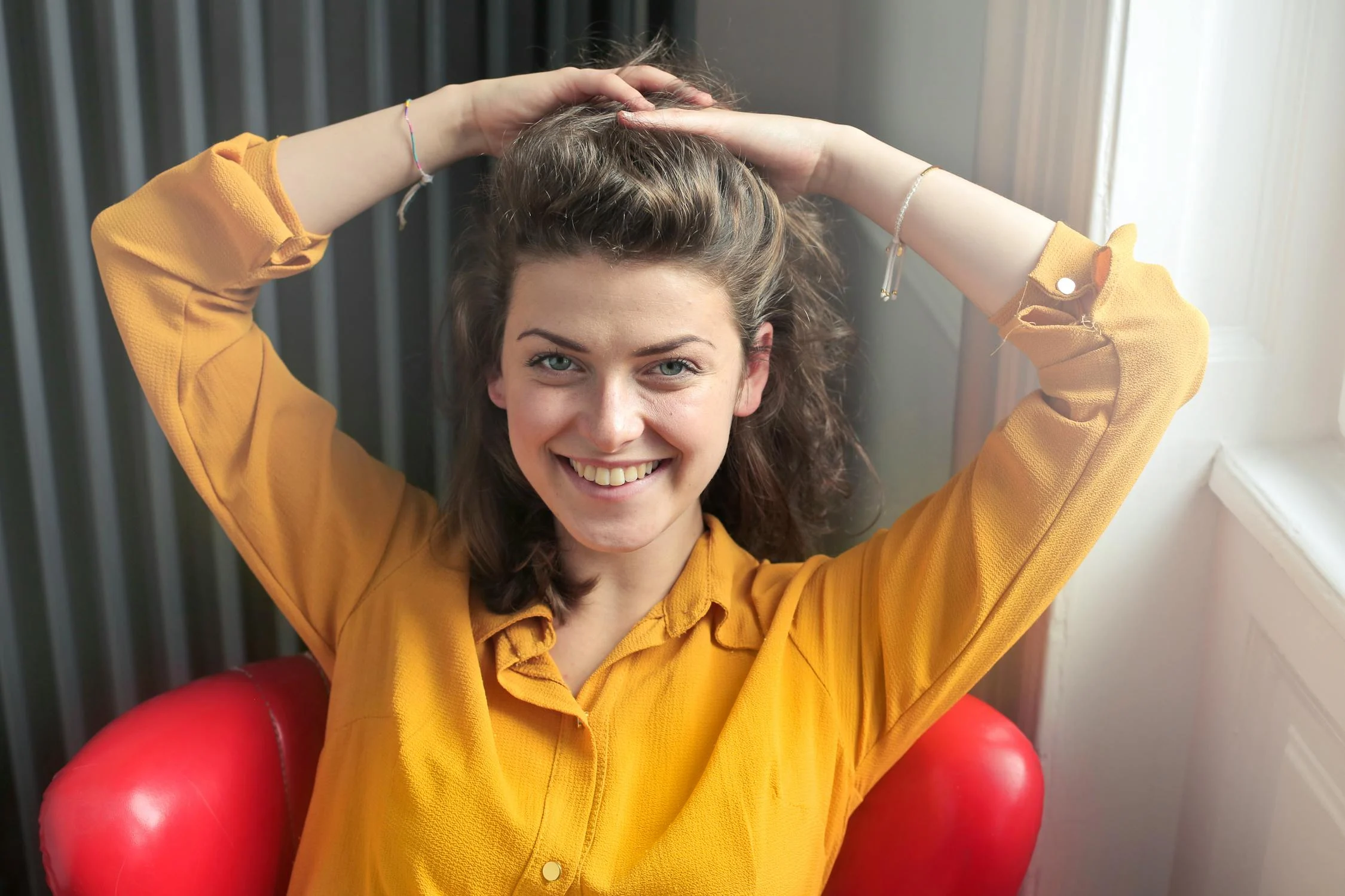 A smiling woman in a chair | Source: Pexels