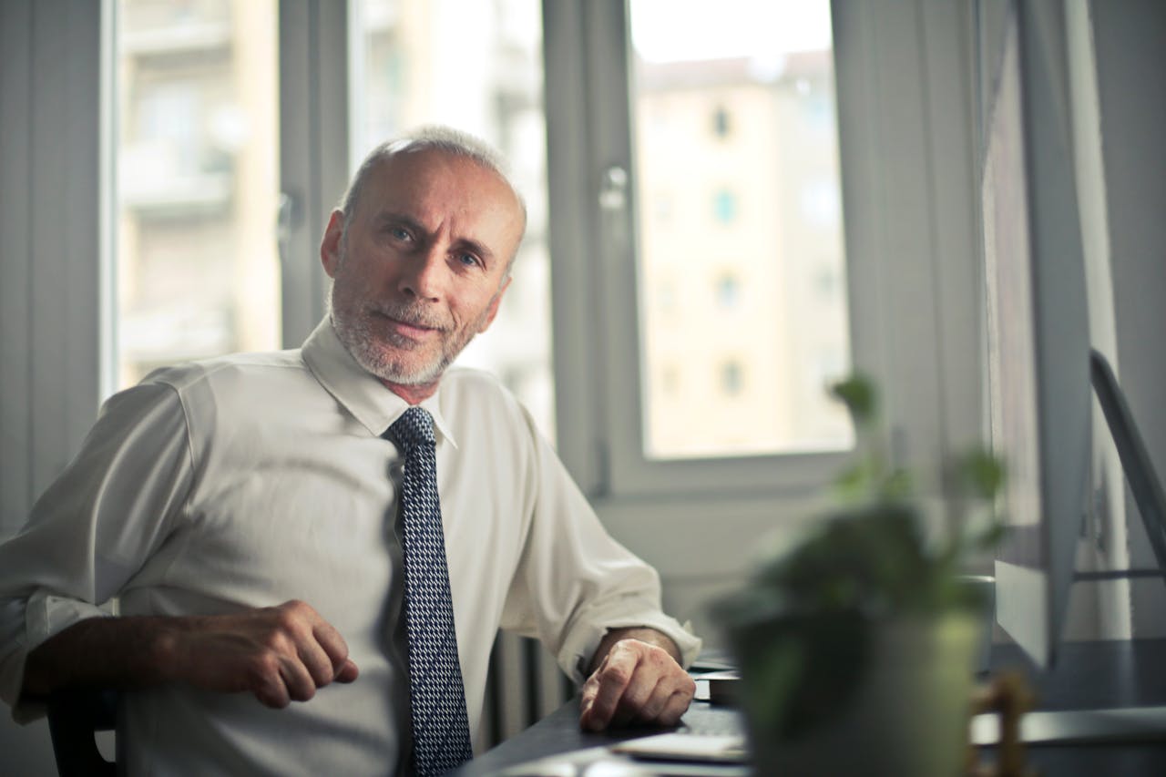 An older man sitting in his office | Source: Pexels