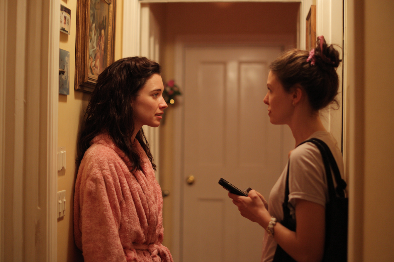 Two women speaking in a home hallway | Source: Midjourney