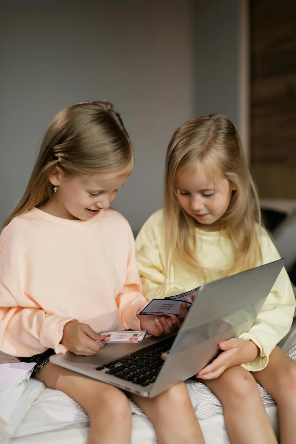 Twin sisters playing with a laptop | Source: Pexels