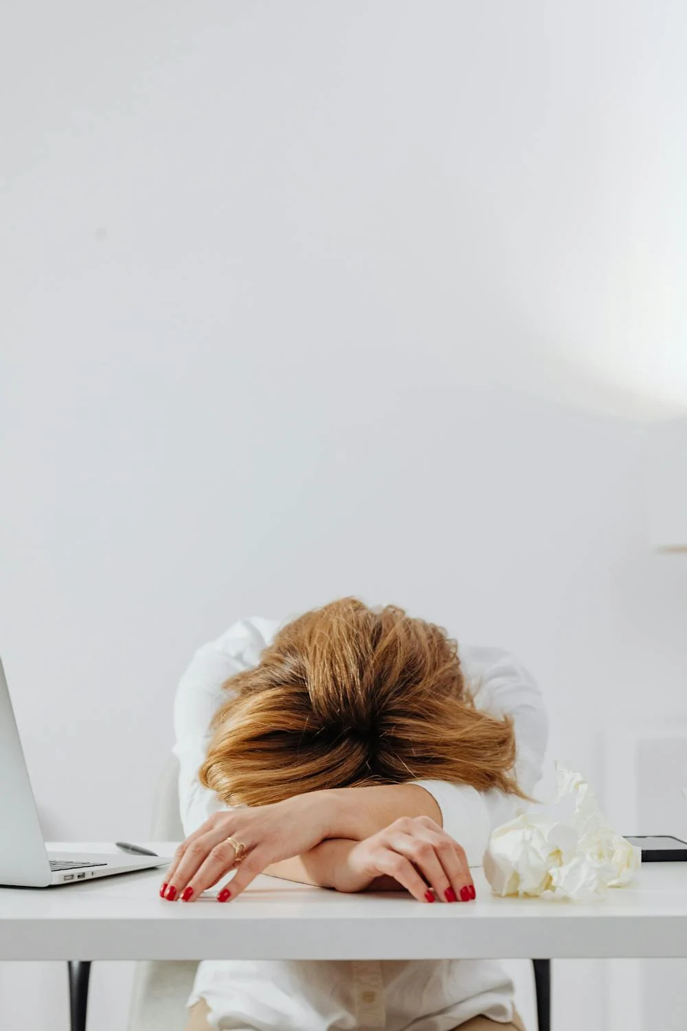 A tired woman lying on her table | Source: Pexels