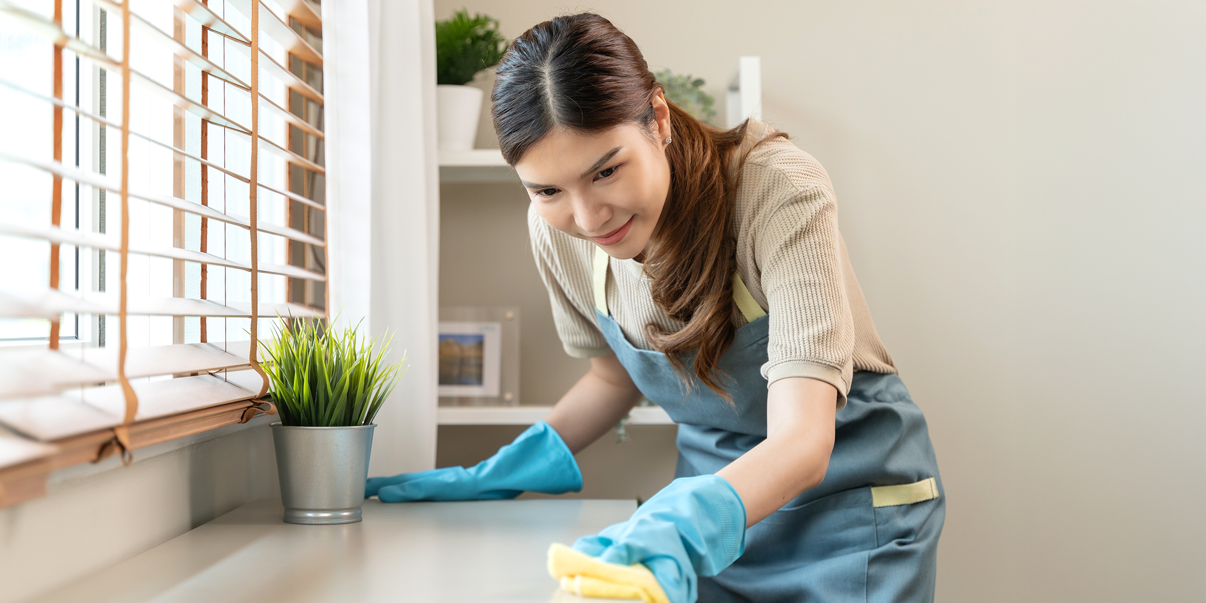 A woman wiping a countertop | Source: Shutterstock