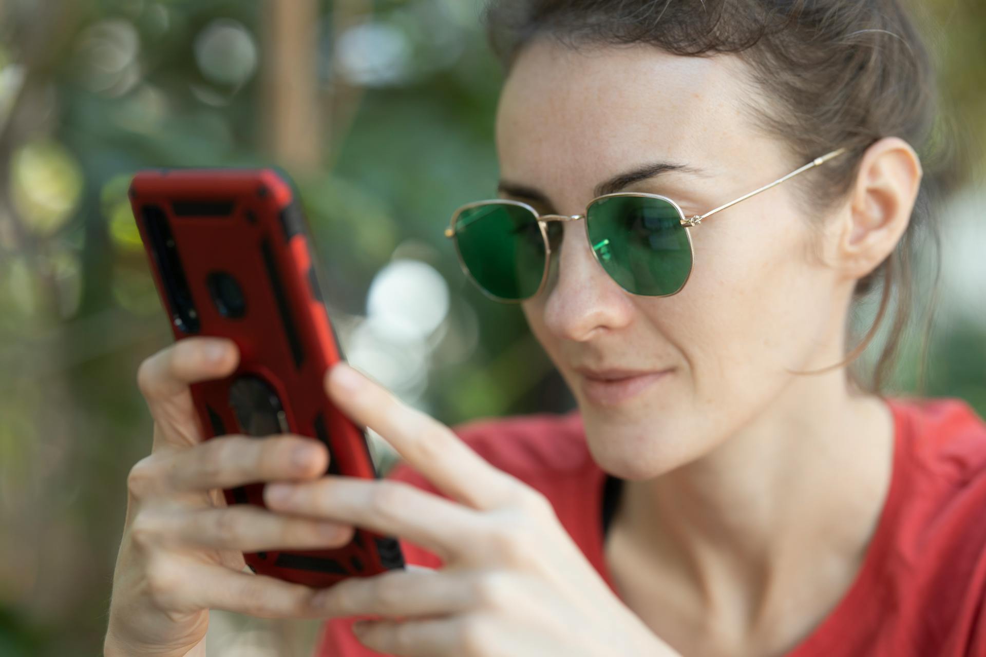 A woman smirking while reading a text message | Source: Pexels