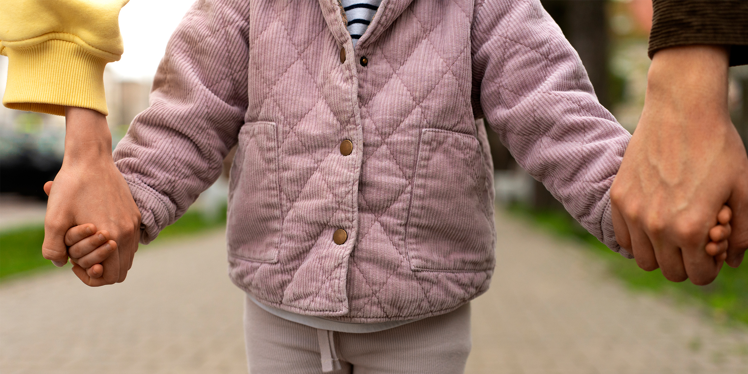 A man and woman holding hands with a child | Source: Freepik