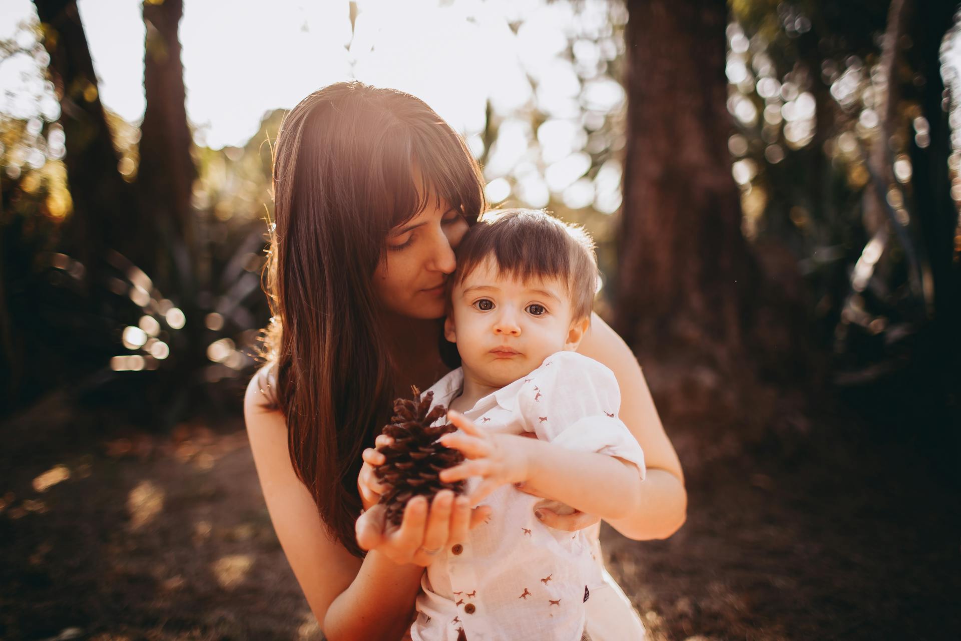 A mother and her son holding a pine cone | Source: Pexels