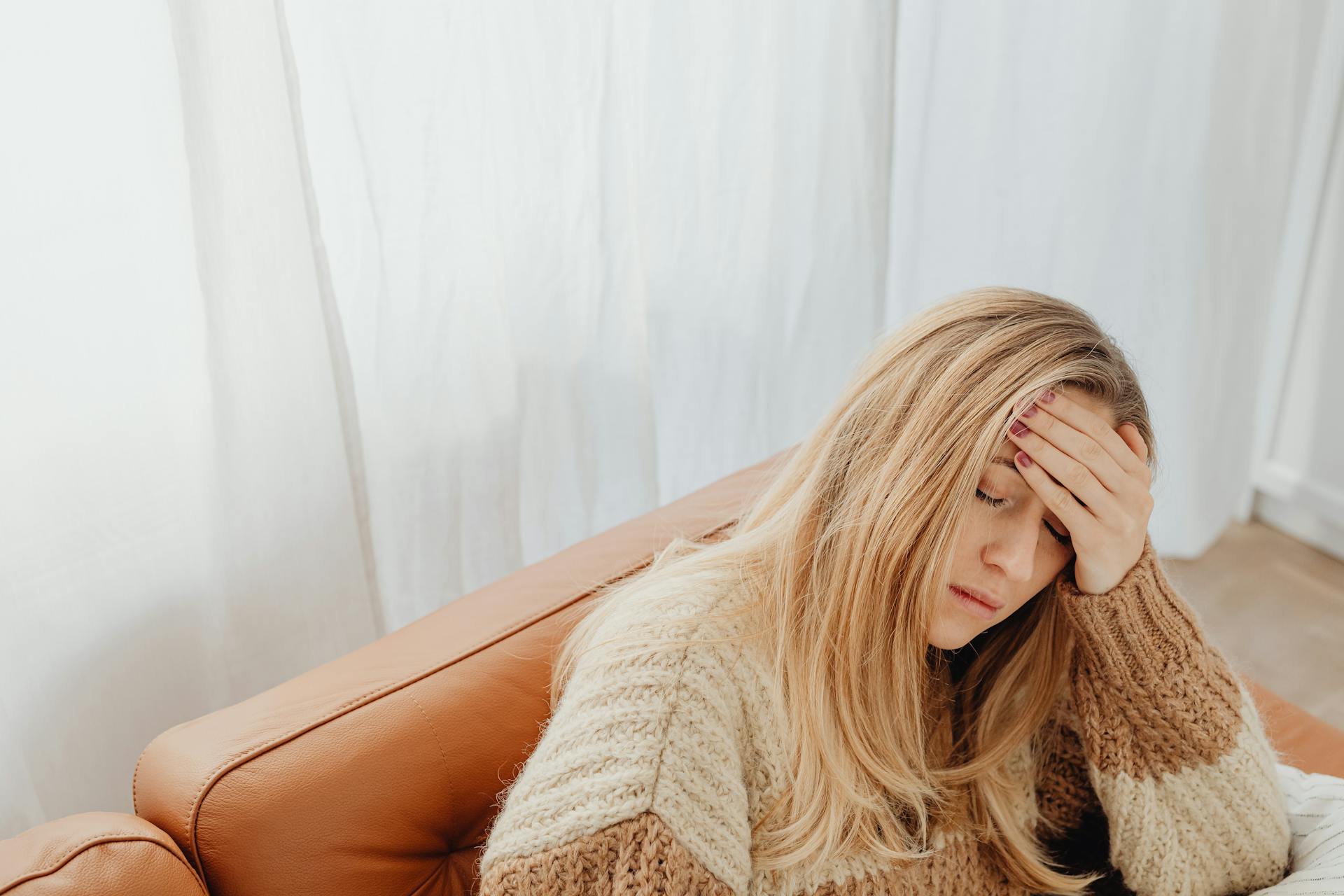 A tired woman sitting on a couch | Source: Pexels