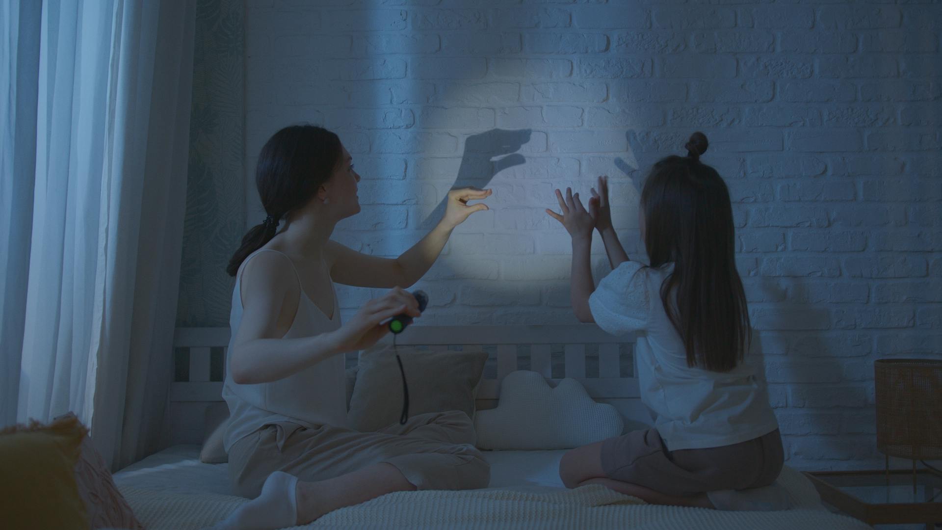 A woman and her daughter creating shadow puppets | Source: Pexels