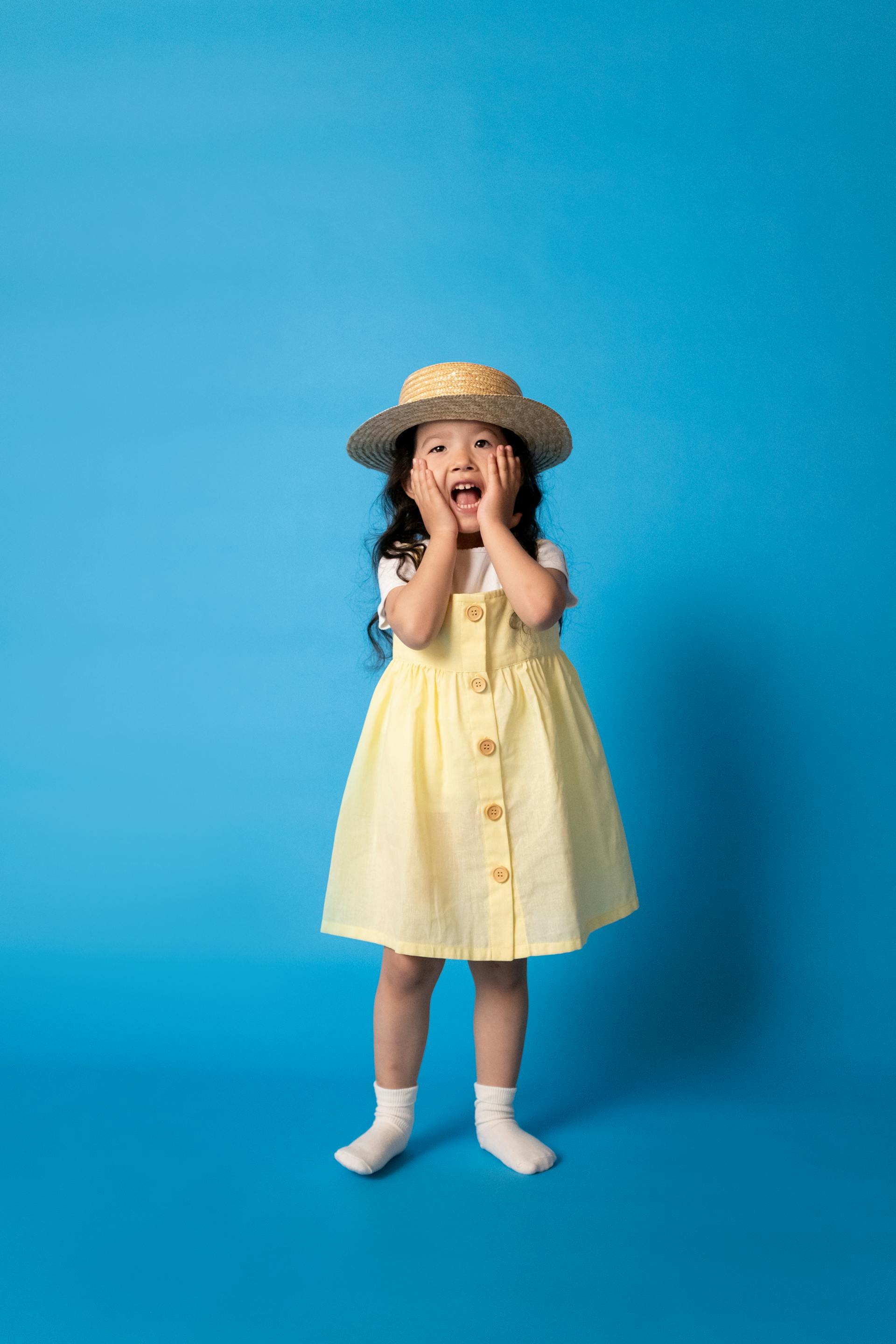 A little girl holding her cheeks | Source: Pexels