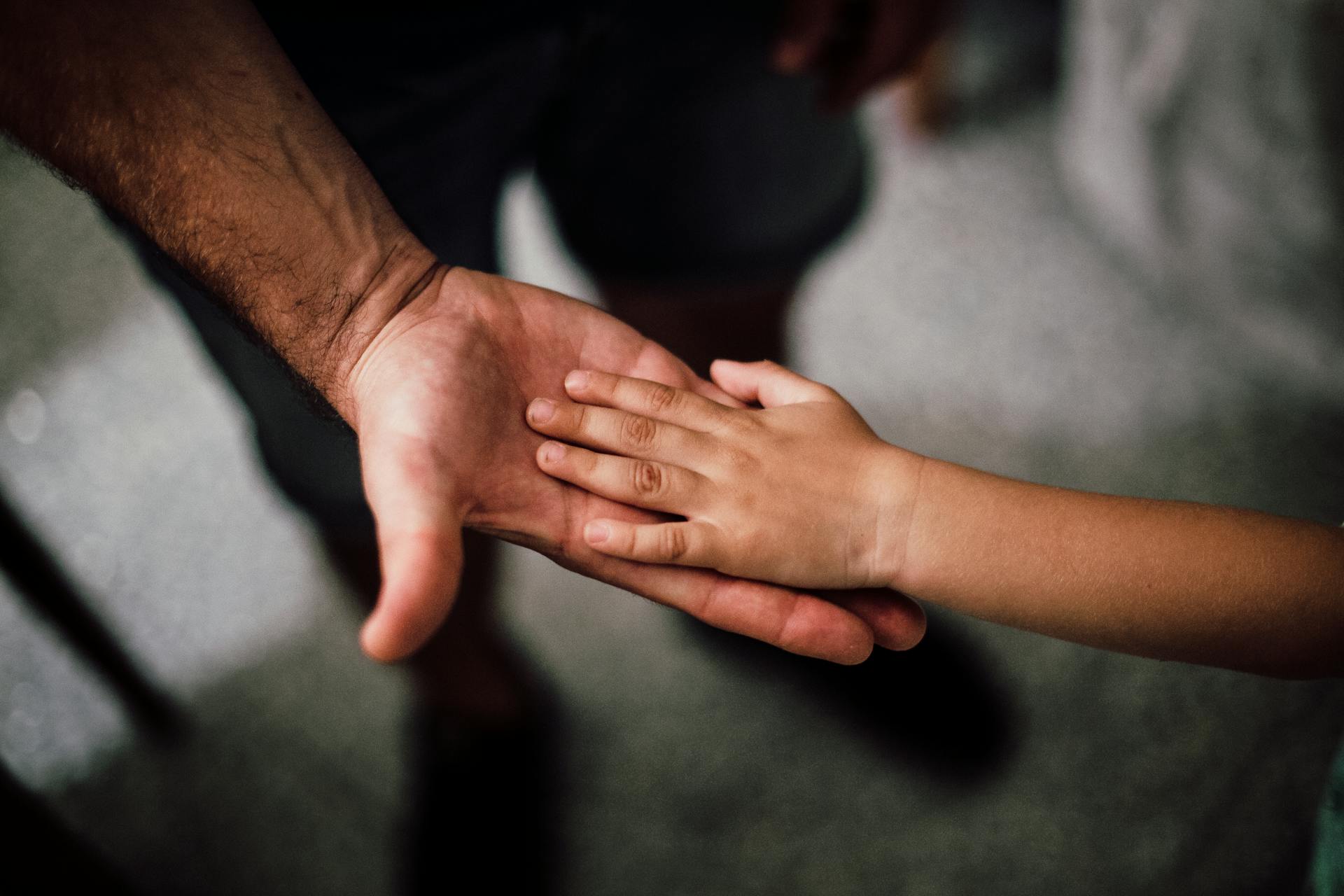 Nostalgic shot of a father holding his child's hand | Source: Pexels