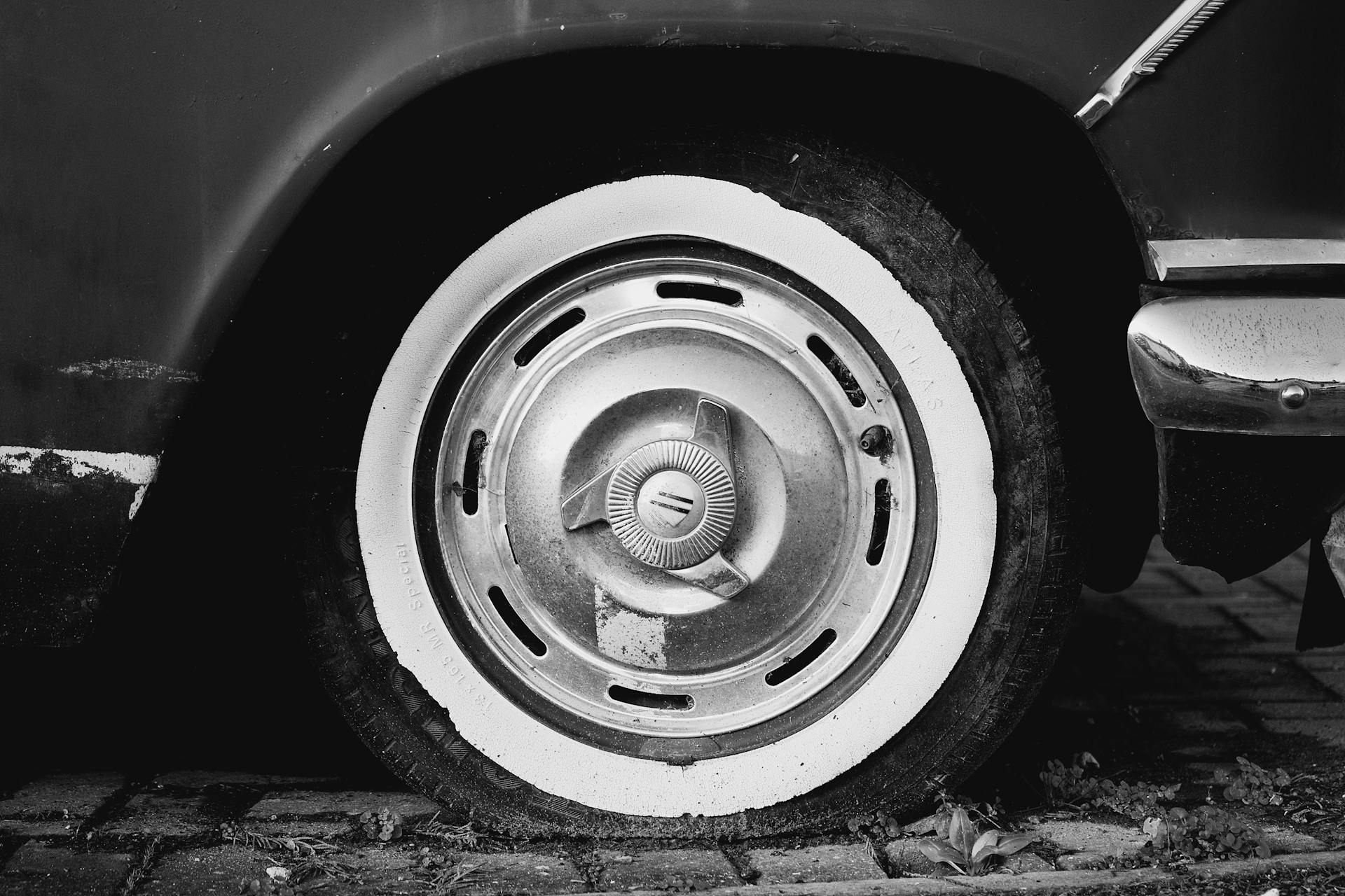 Grayscale photo of a flat car tire | Source: Pexels