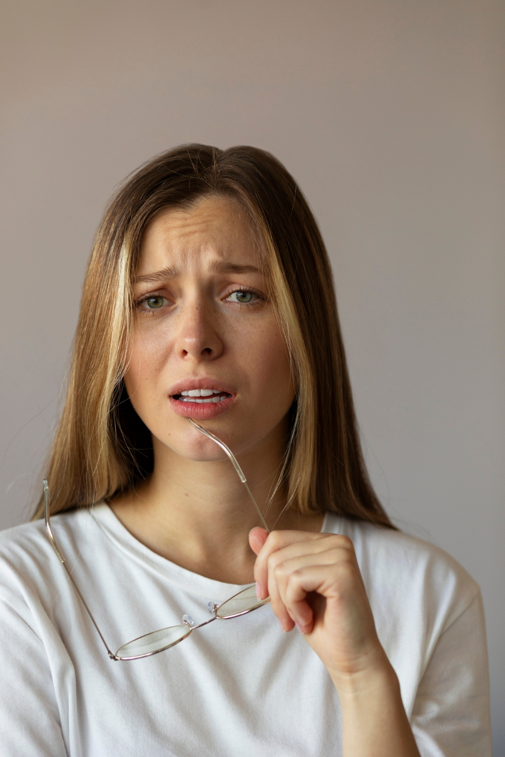 A woman holding her glasses and staring unkindly | Source: Freepik