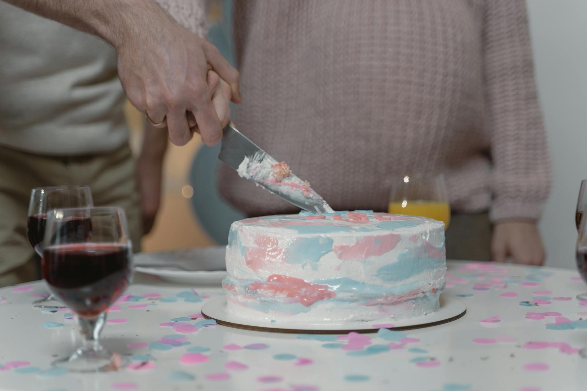 A couple slicing their gender reveal cake | Source: Pexels