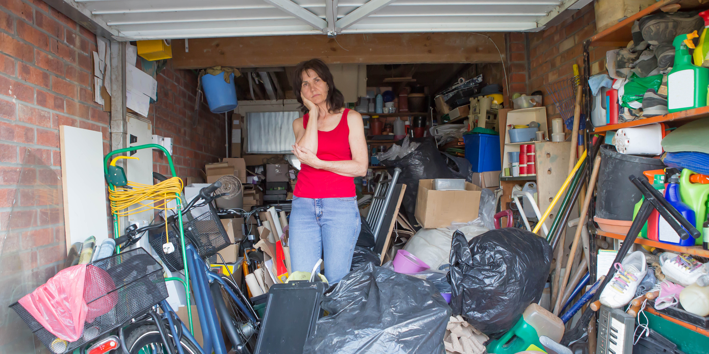 A tense woman standing in a messy garage | Source: Shutterstock