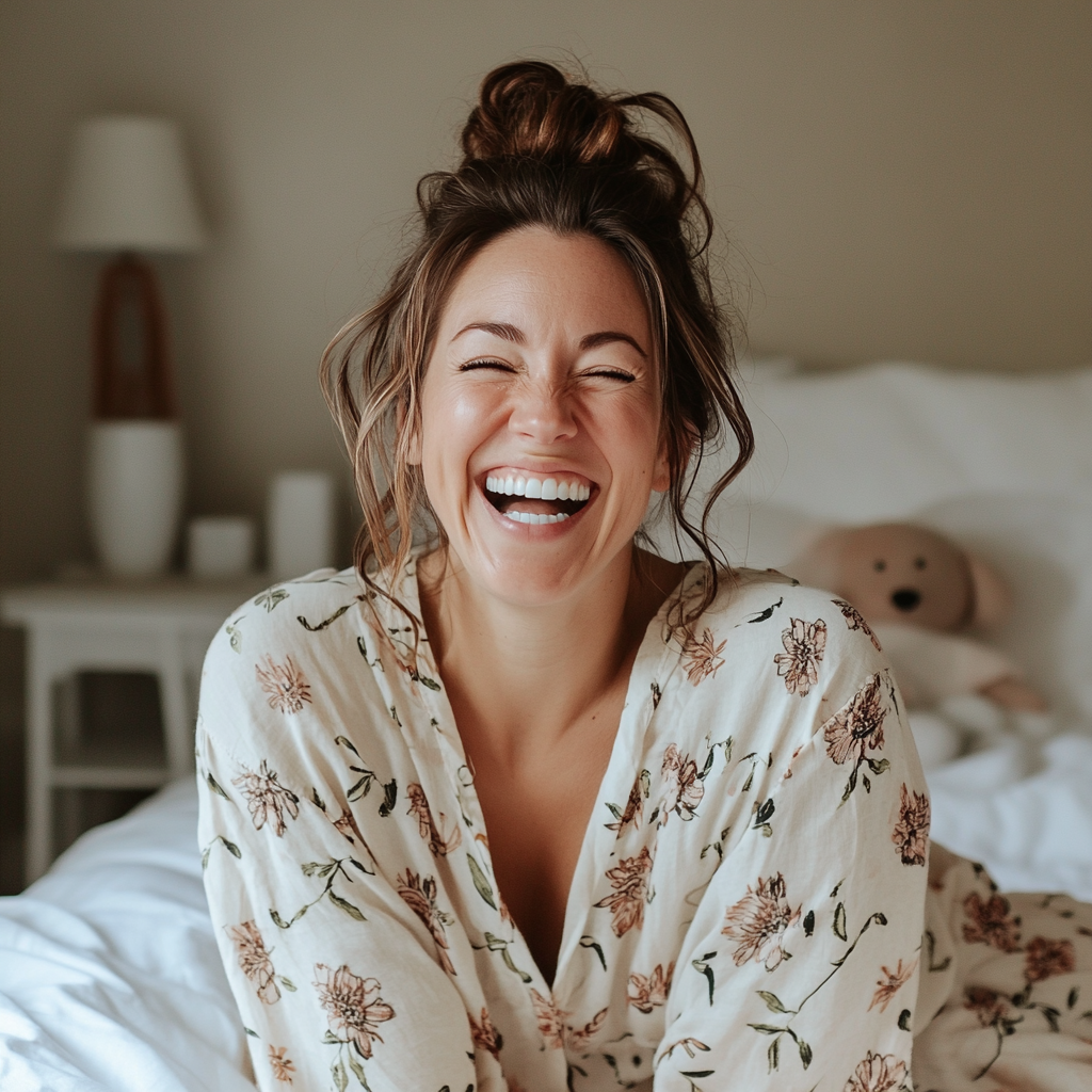 Uma mulher sentada na cama e rindo | Fonte: Midjourney