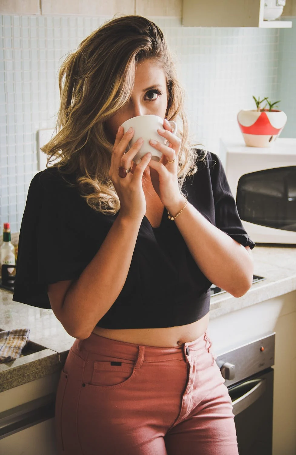 A woman drinking coffee in her kitchen | Source: Pexels