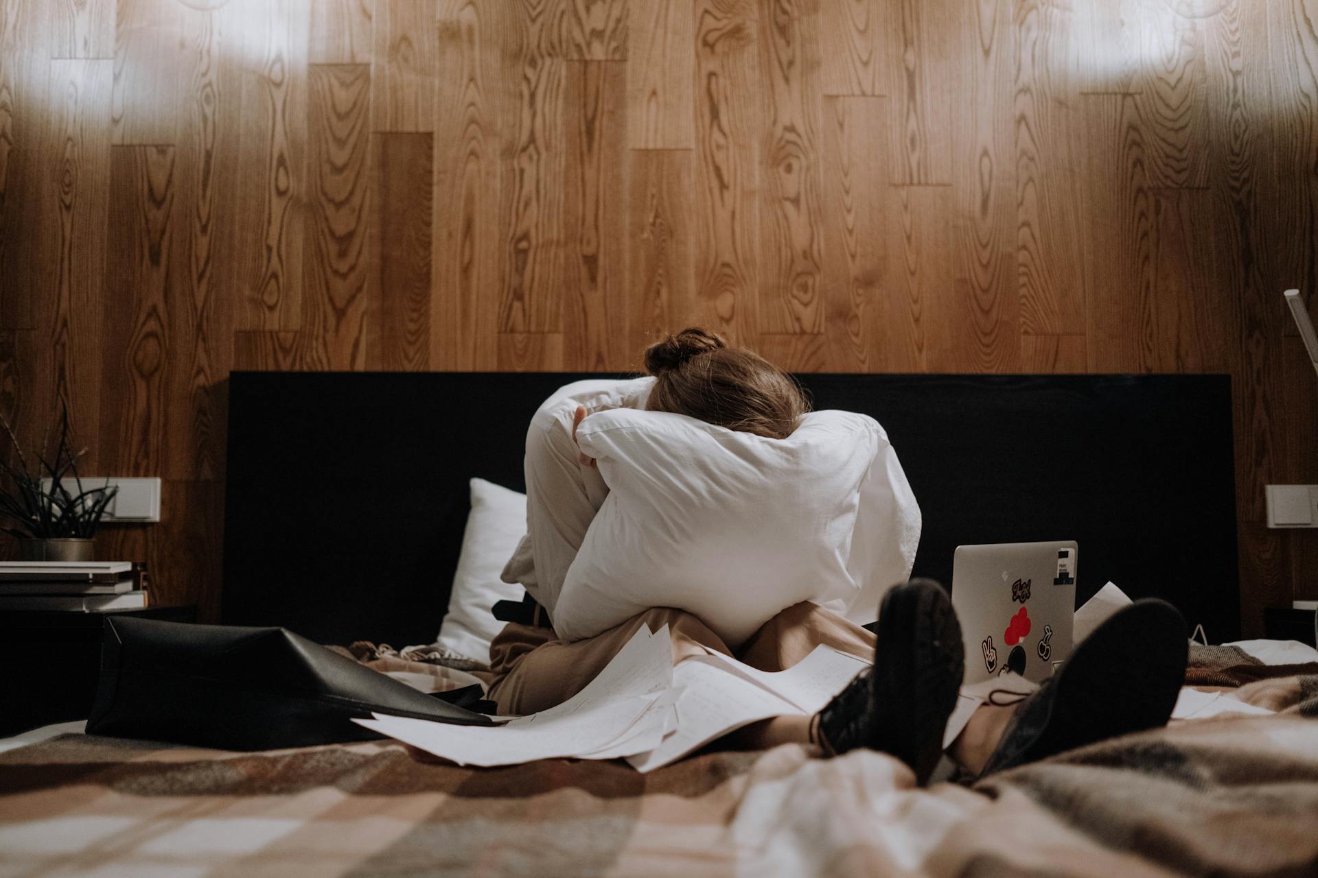 A heartbroken woman crying into her pillow in the bedroom | Source: Pexels